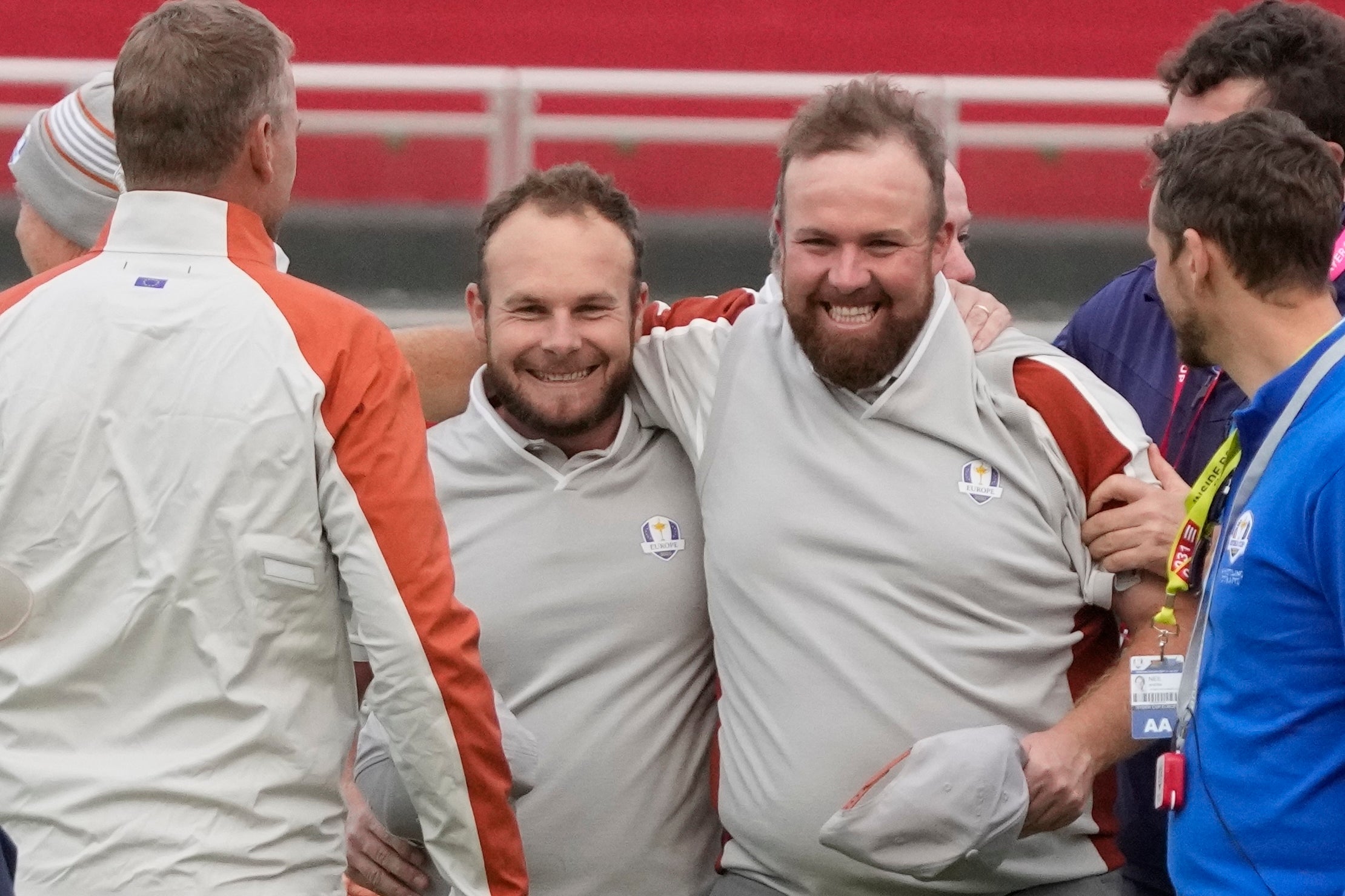 Lowry and Tyrrell Hatton celebrate on the 18th hole after winning their fourball match (Charlie Neibergall/AP)