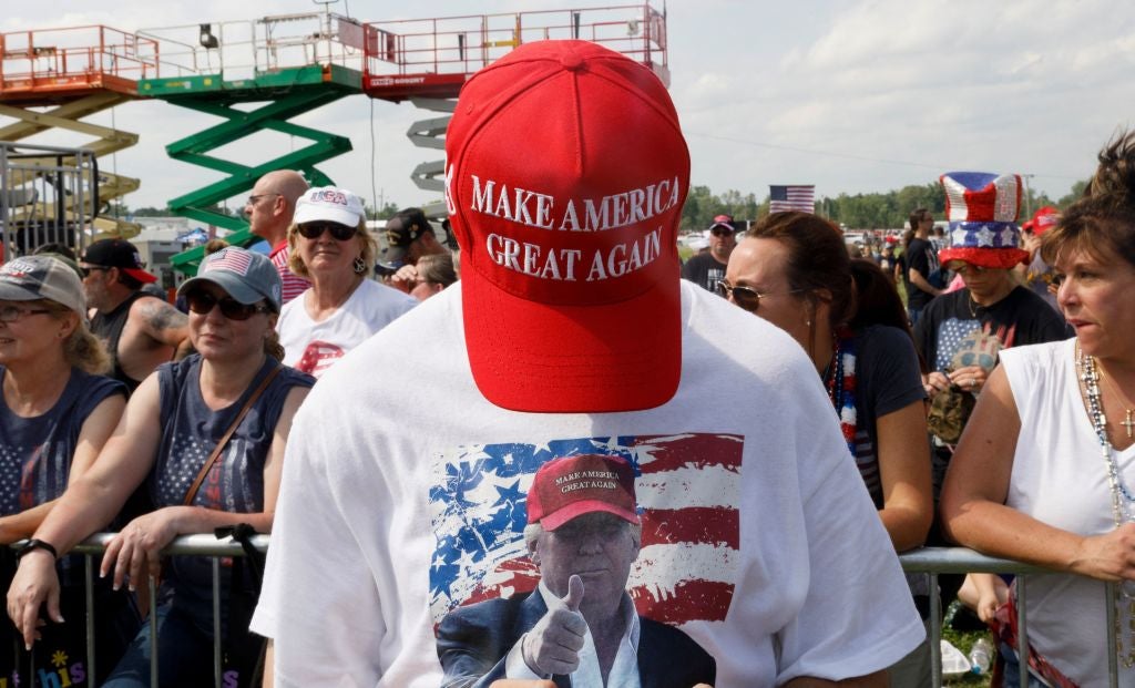 A Trump supporter shows his MAGA hat at an Ohio rally in June