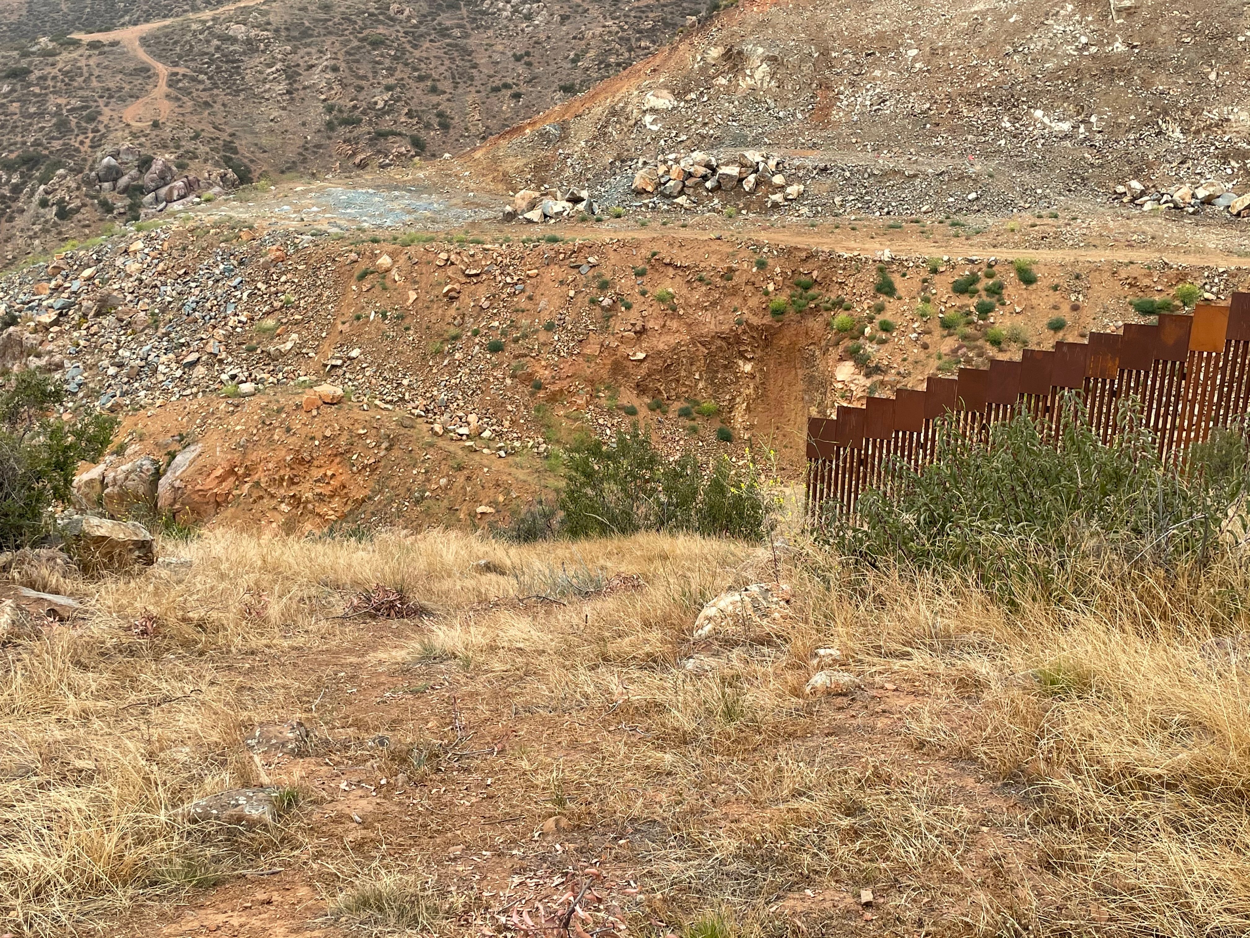 Border wall construction in the Otay Mountain wilderness involved heavy machinery and blasting dynamite. The fencing has been left with a large gap