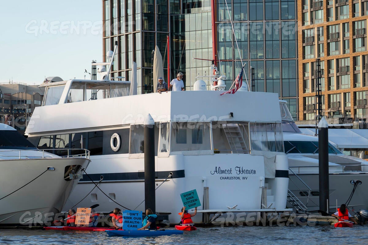 Activists demonstrate in the water near the houseboat owned by Senator Joe Manchin