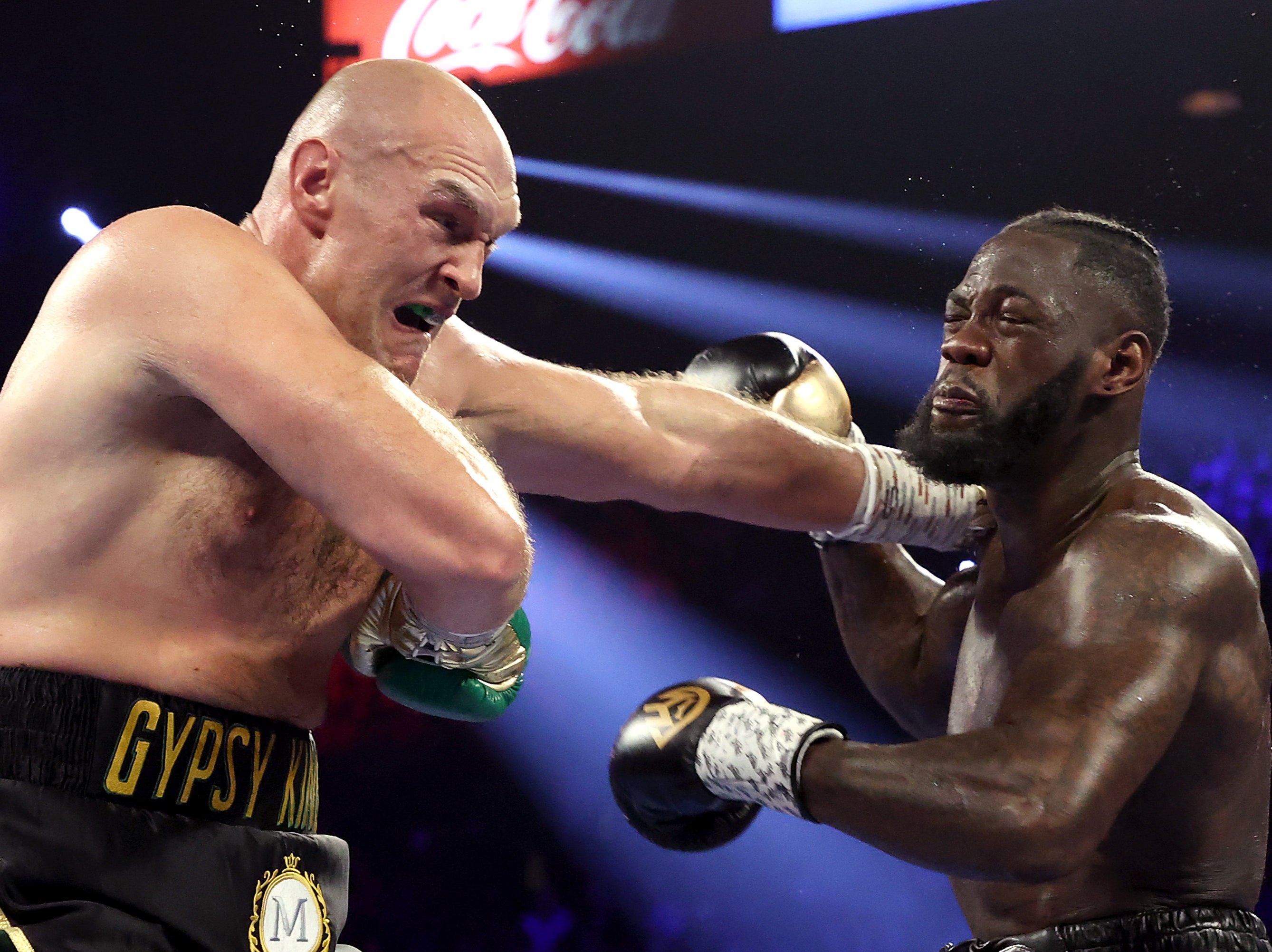 Deontay Wilder (derecha) y Tyson Fury intercambian golpes en su revancha.