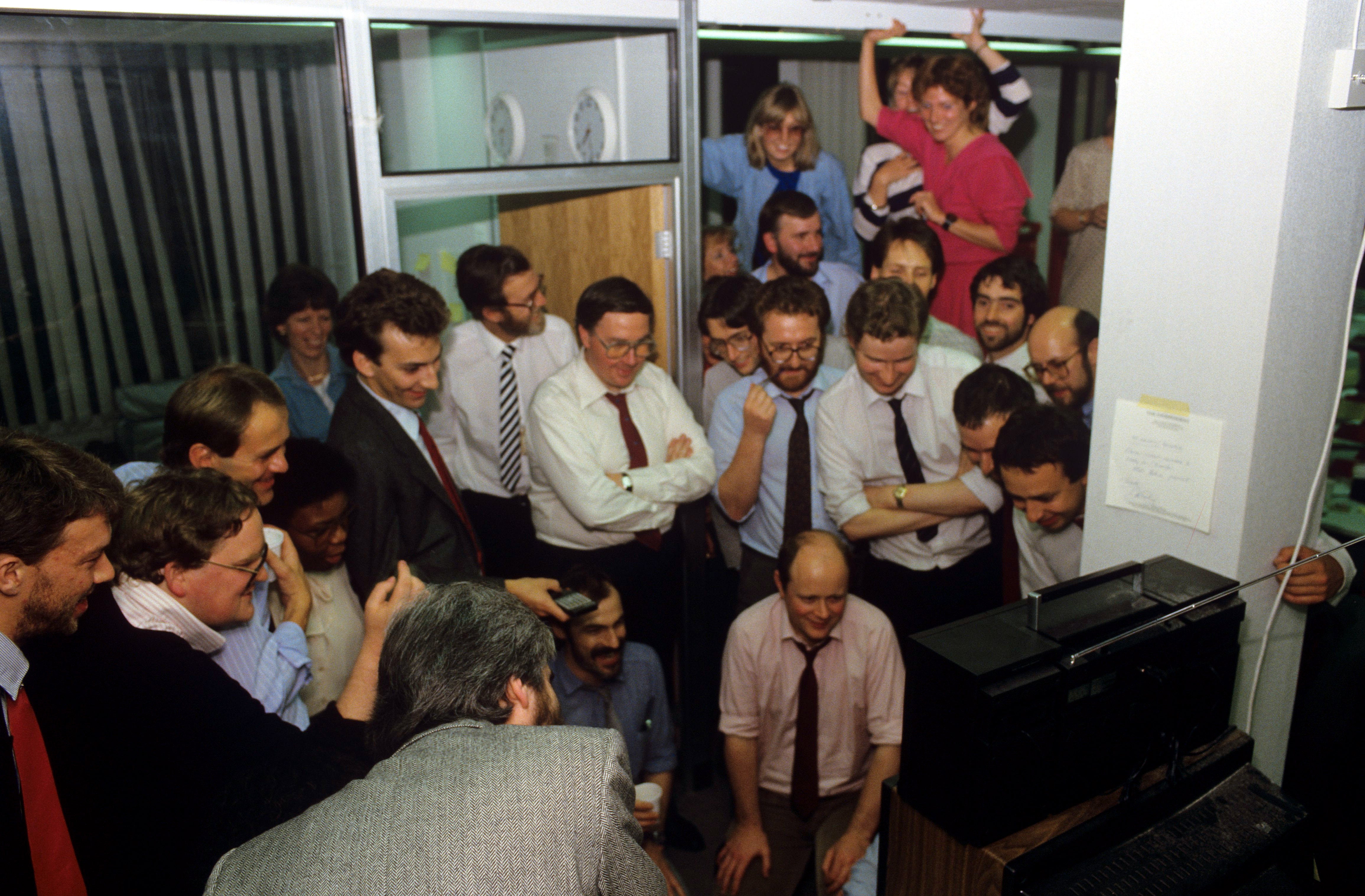 Celebrating journalists watch the reaction on TV to the first edition of The Independent newspaper, 6 October 1986