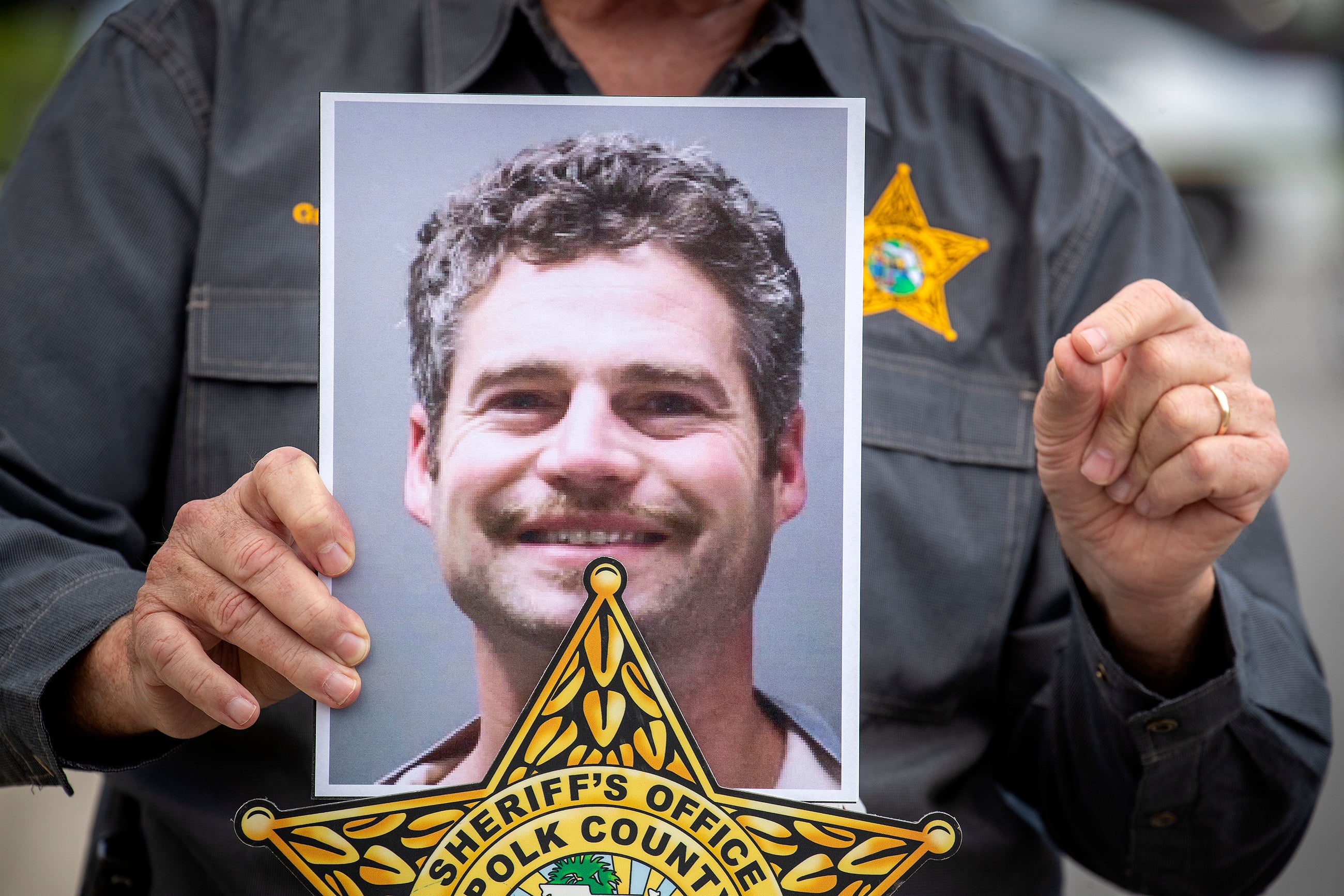 Polk County Sheriff Grady Judd holds up a photo of Shaun Runyon, who is accused of killing his co-workers