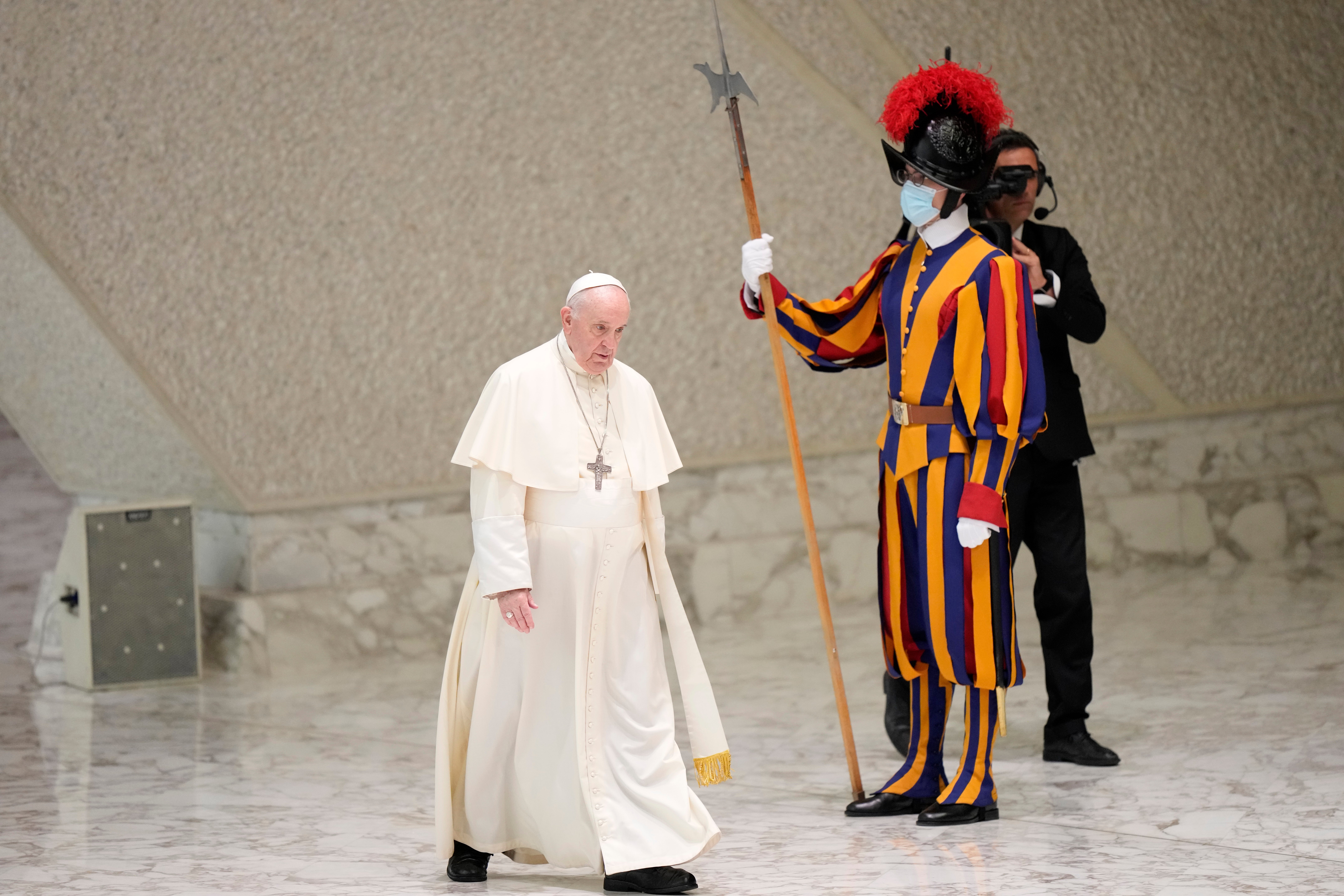 Pope Francis walks past a Vatican Swiss Guard as he arrives for his weekly general audience in the Paul VI hall, at the Vatican