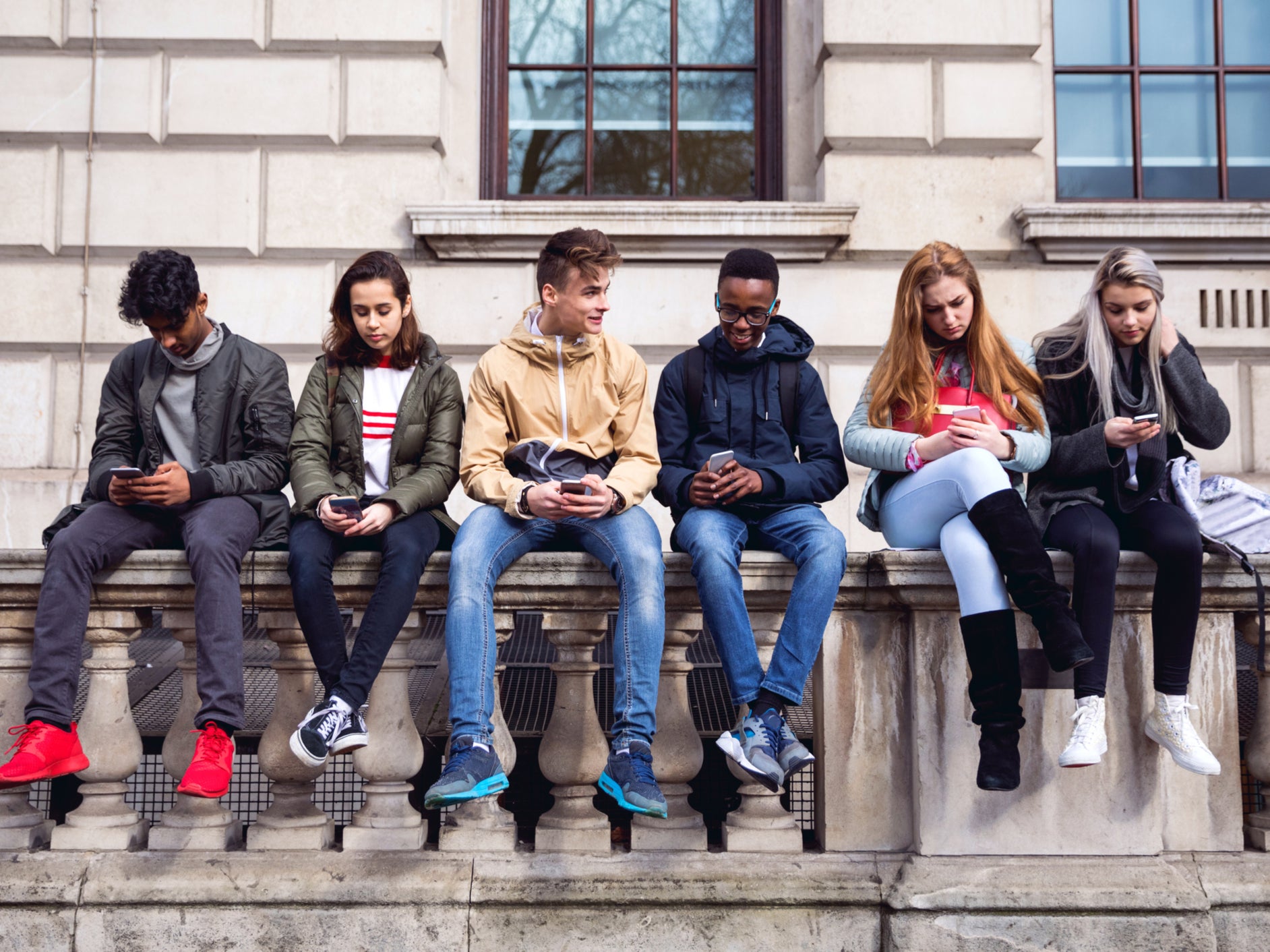 Group of young teenagers sitting side by side