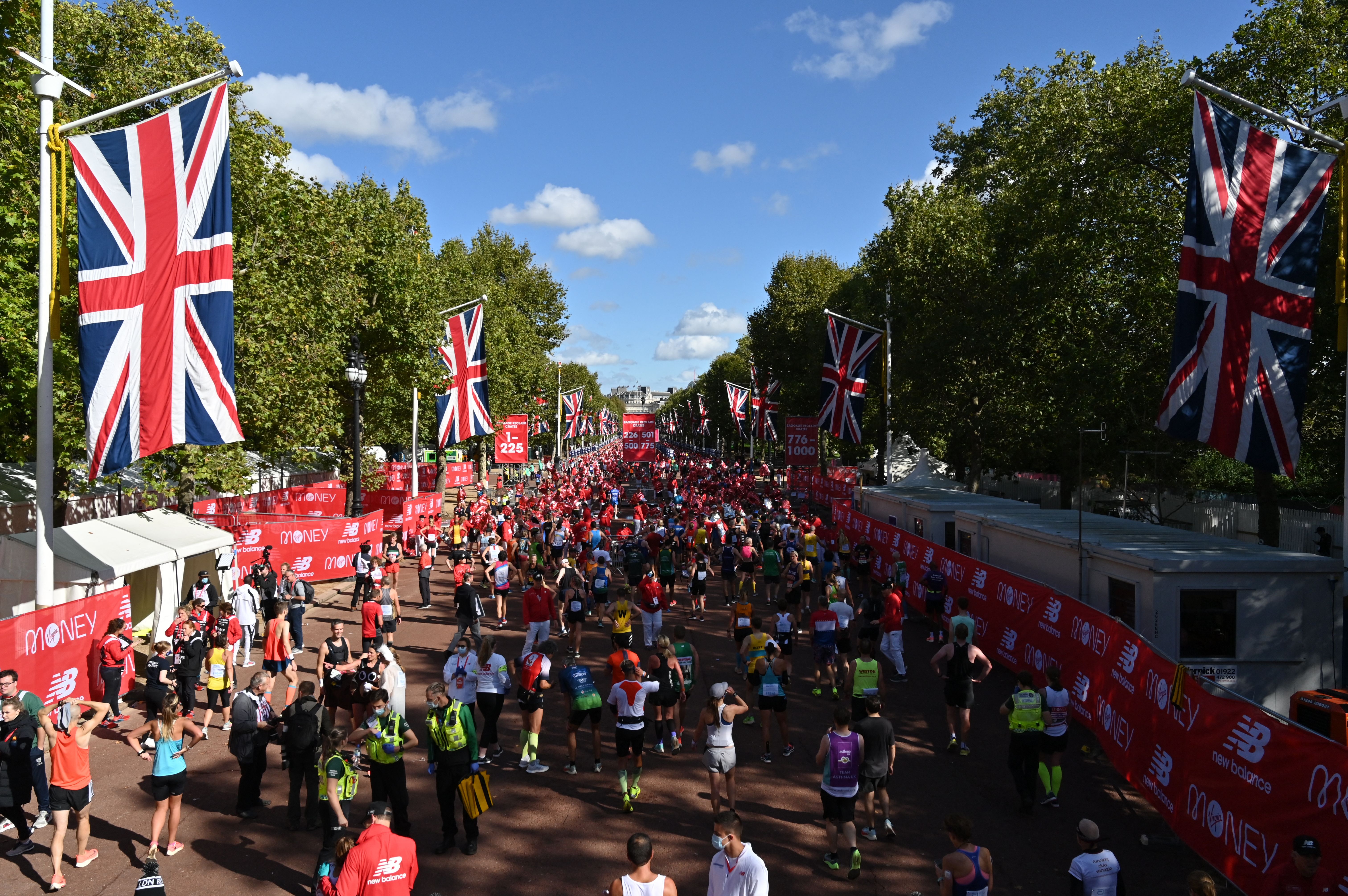 Runners relax on the Mall after finishing the 2021 London Marathon