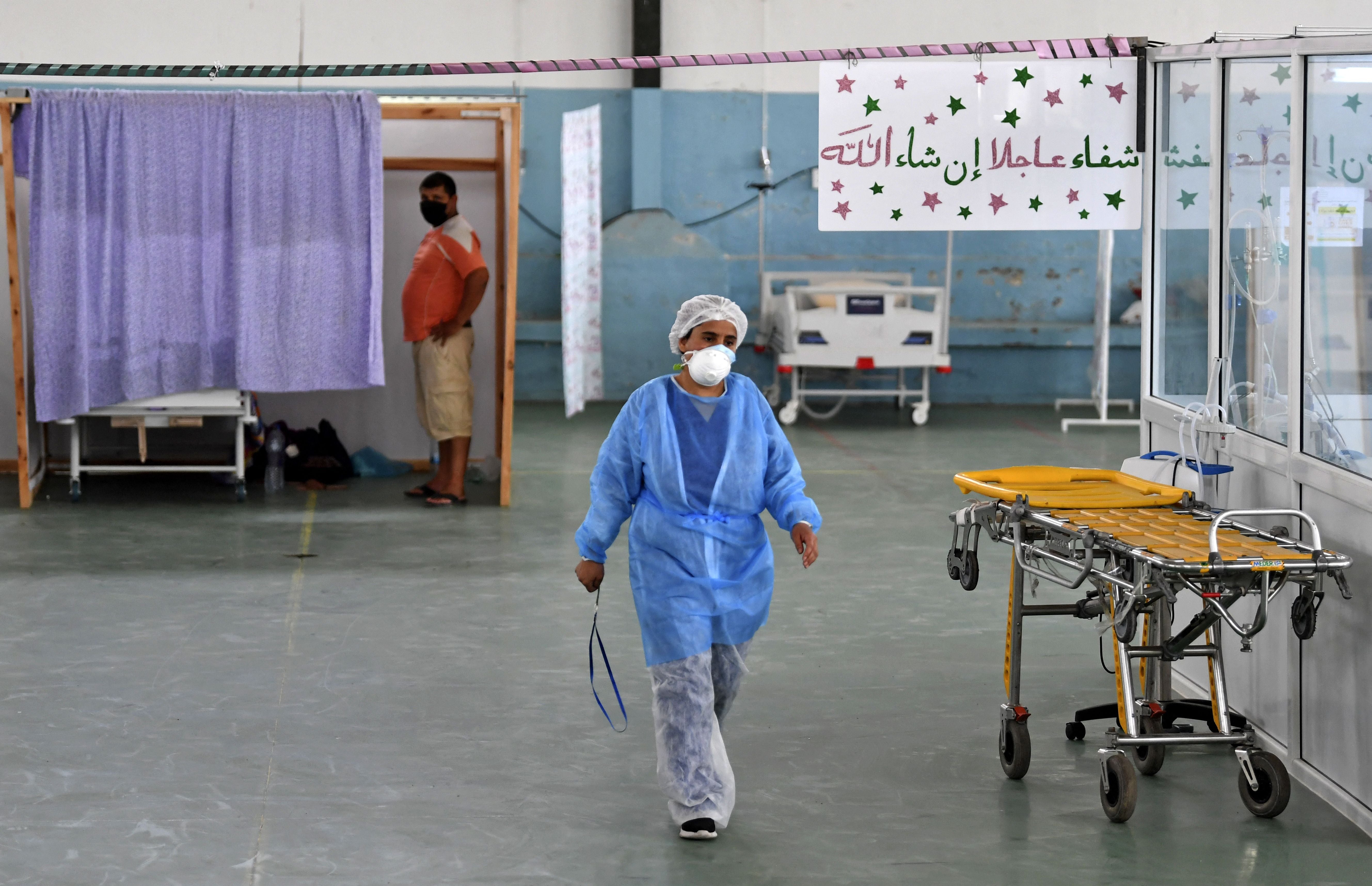 A doctor attends to a patient at a gym that was converted to deal with a surge in new Covid-19 infections in the east-central city of Kairouan