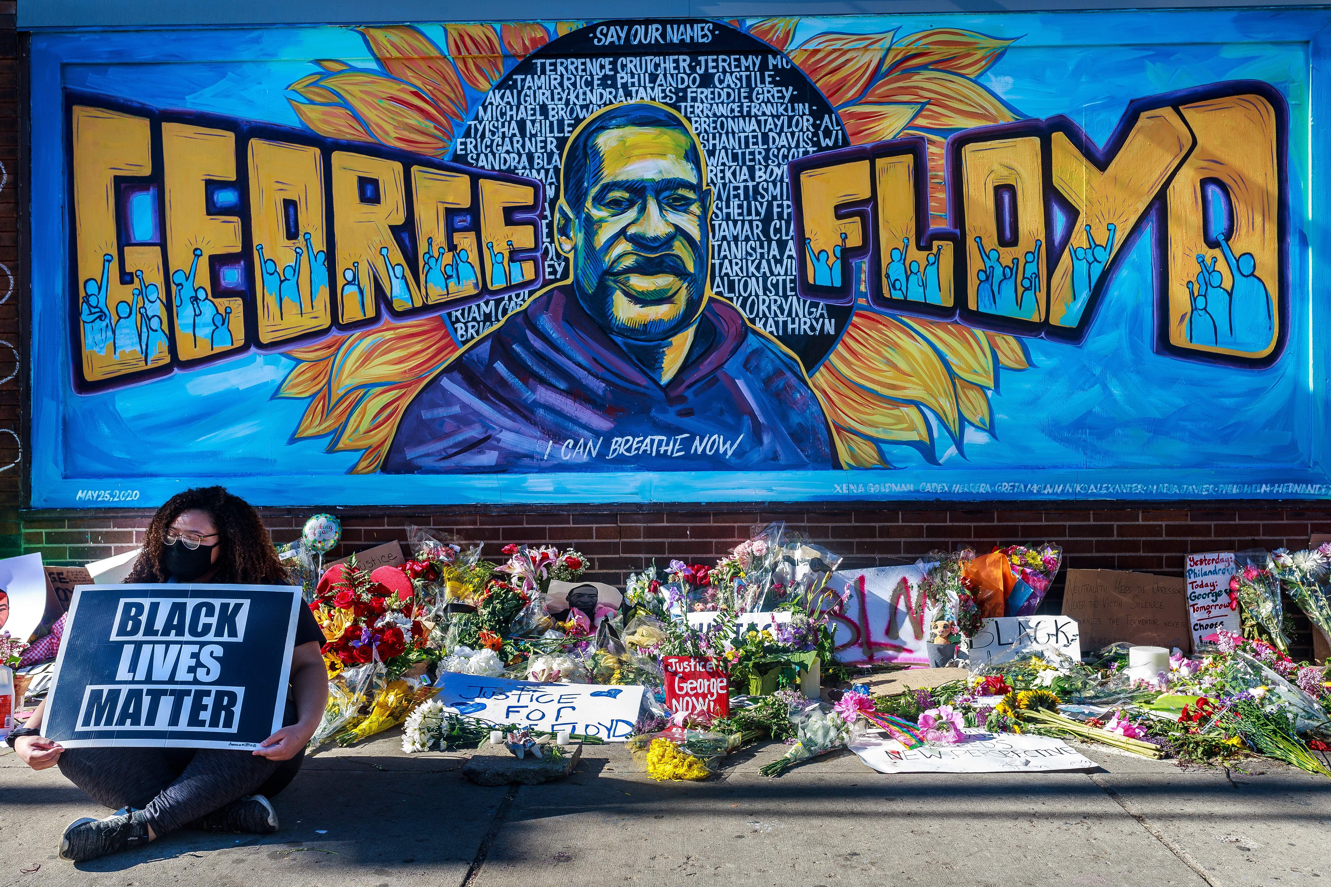 Flowers, signs and balloons are left near a makeshift memorial to George Floyd near the spot where he died in Minneapolis