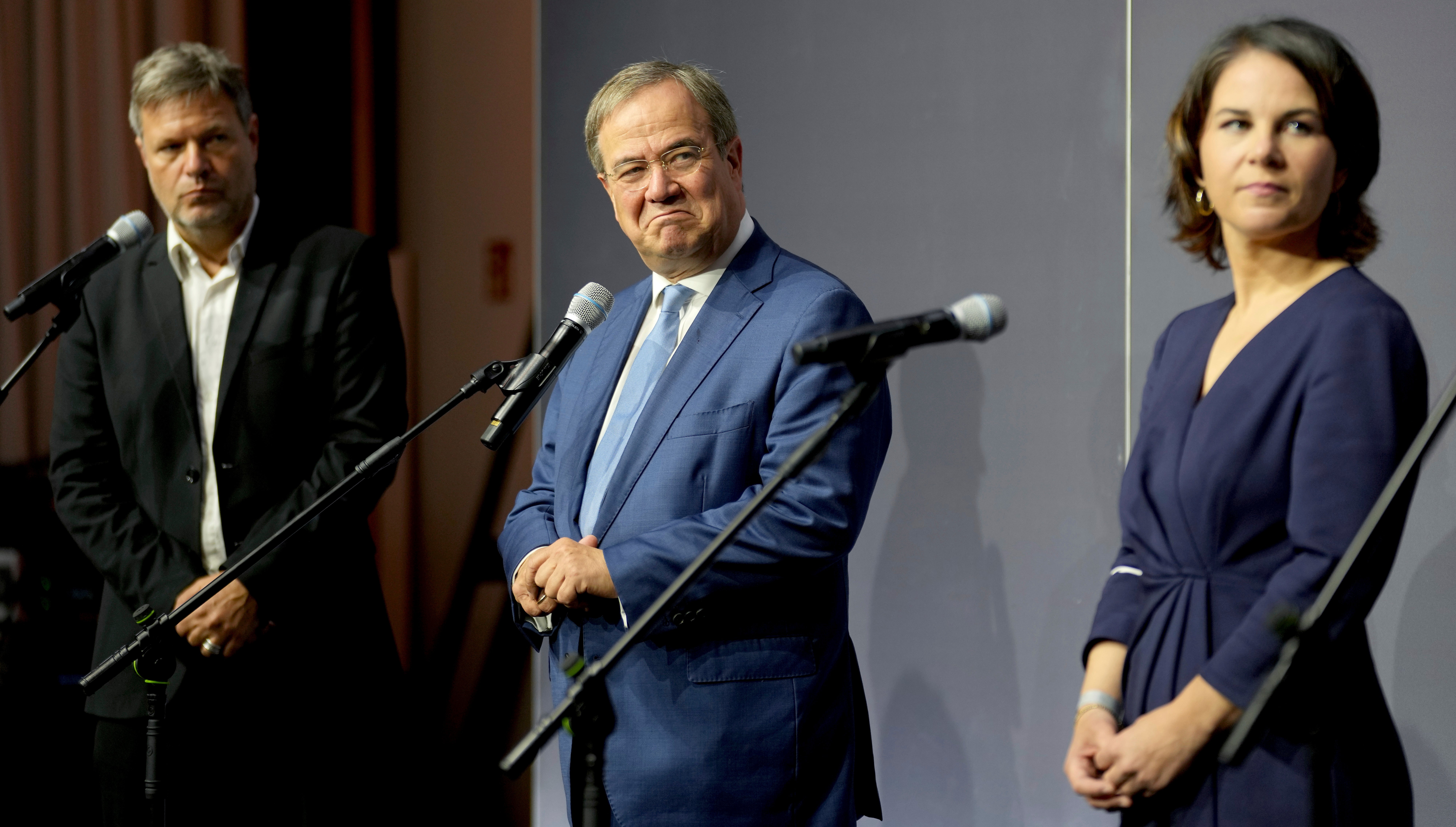 From left, Robert Habeck, co-chairman of the German Green party (Die Gruenen), Armin Laschet, chairman of the German Christian Democratic Party (CDU), and Annalena Baerbock, co-chairwoman of the German Green party (Die Gruenen), attend a statement after a meeting in Berlin, Germany, Tuesday, Oct. 5, 2021.