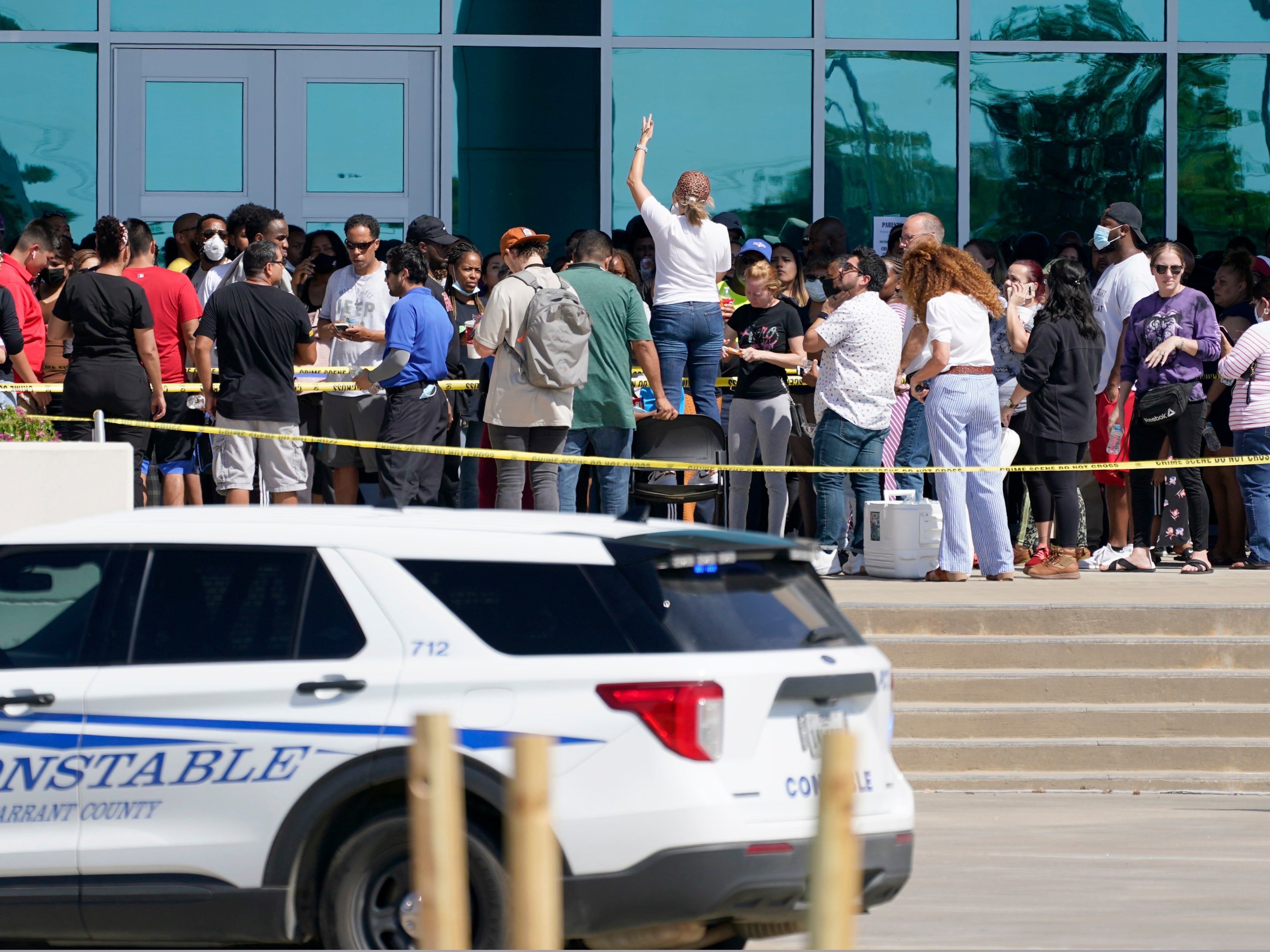 Families are addressed by an unidentified person at center, as they wait to be reunited with their children at the Mansfield ISD Center For The Performing Arts