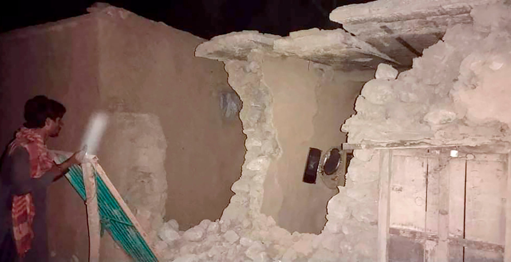 A resident observes the damage to his home