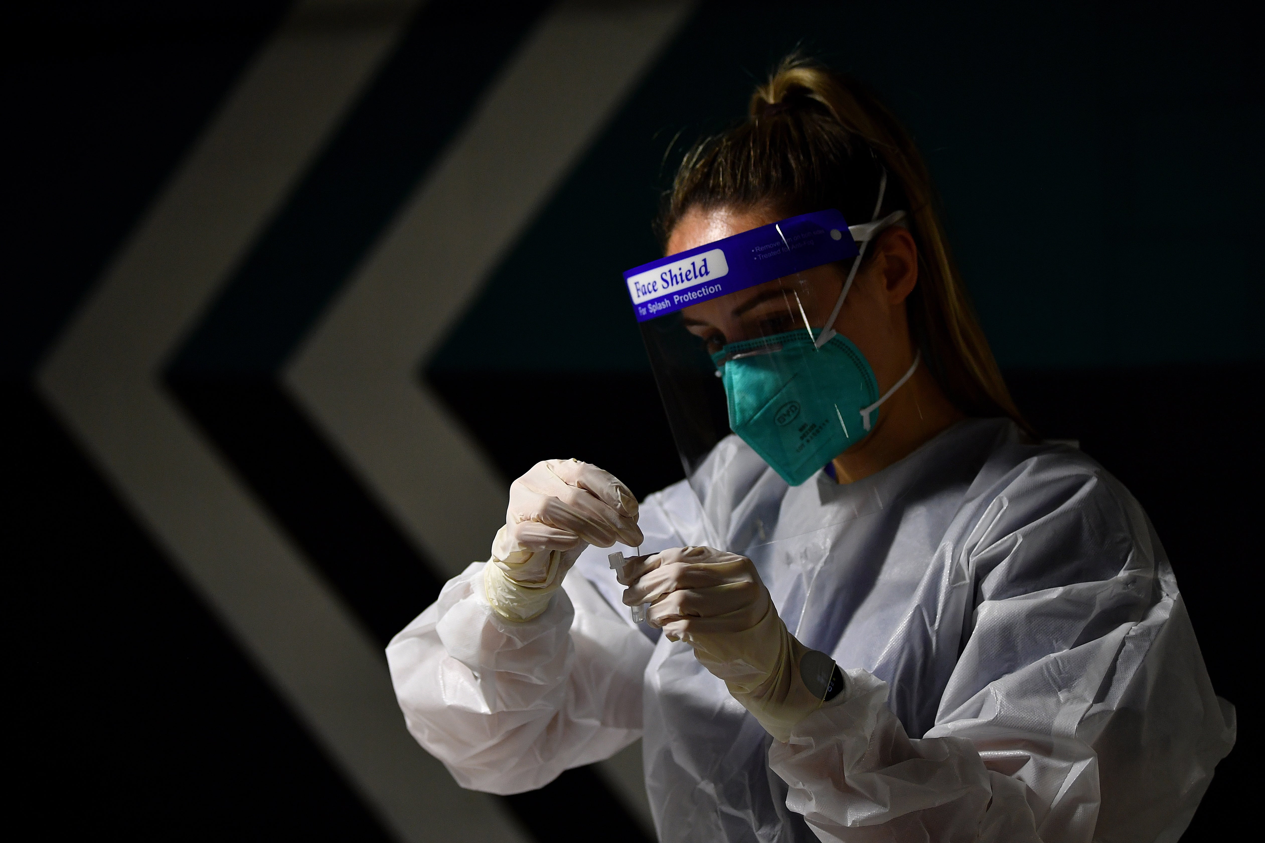 File: A nurse performs a Covid-19 Rapid Antigen test at a drive-through testing facility