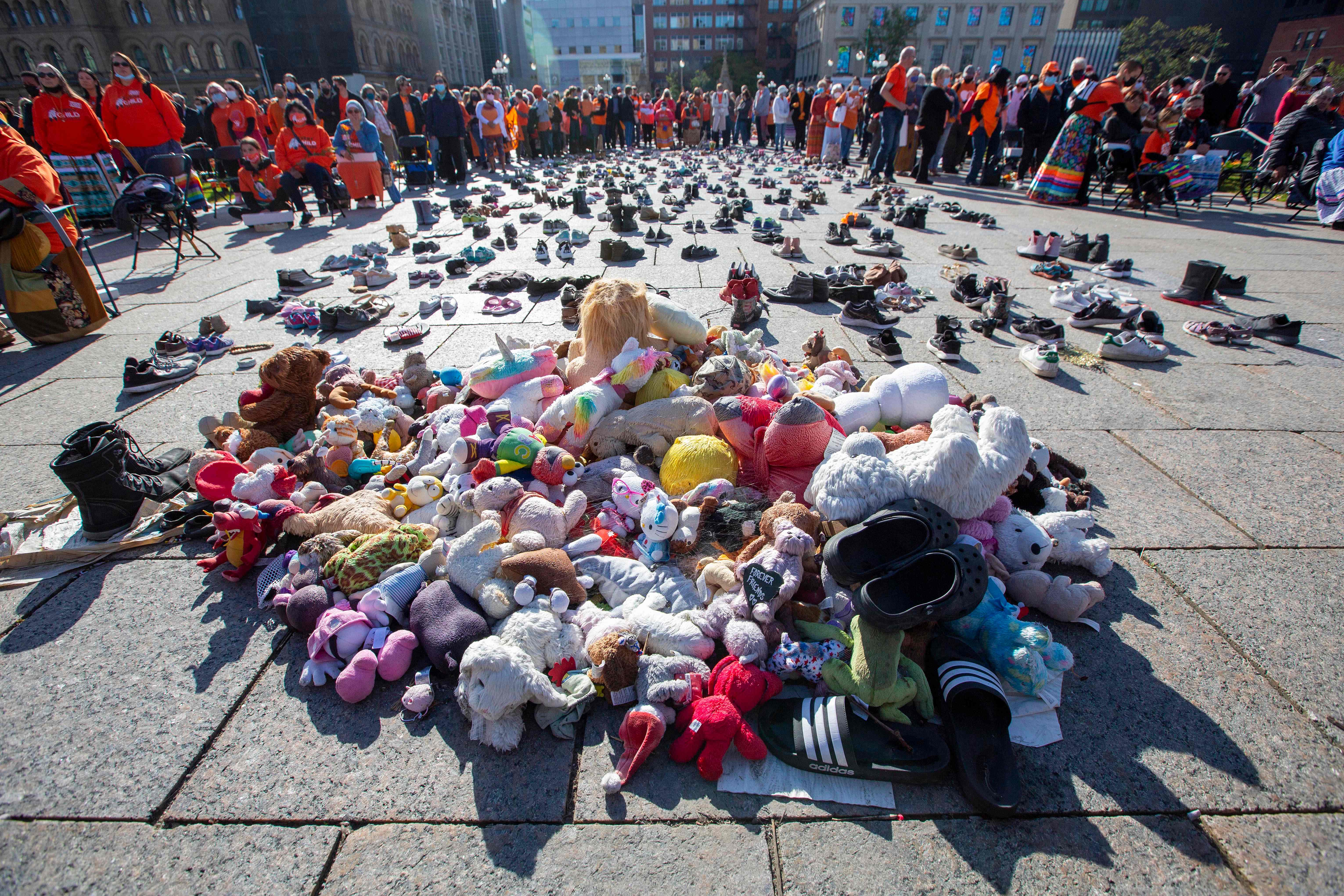 People stand around shoes that honor all the missing indigenous children during the first National Day for Truth and Reconciliation