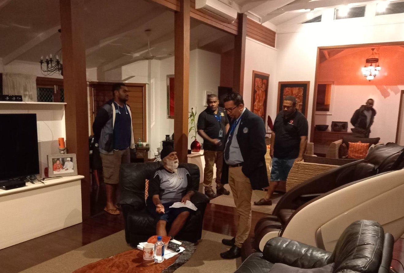 Ahluwalia is surrounded by government officials at his home on the night of his deportation