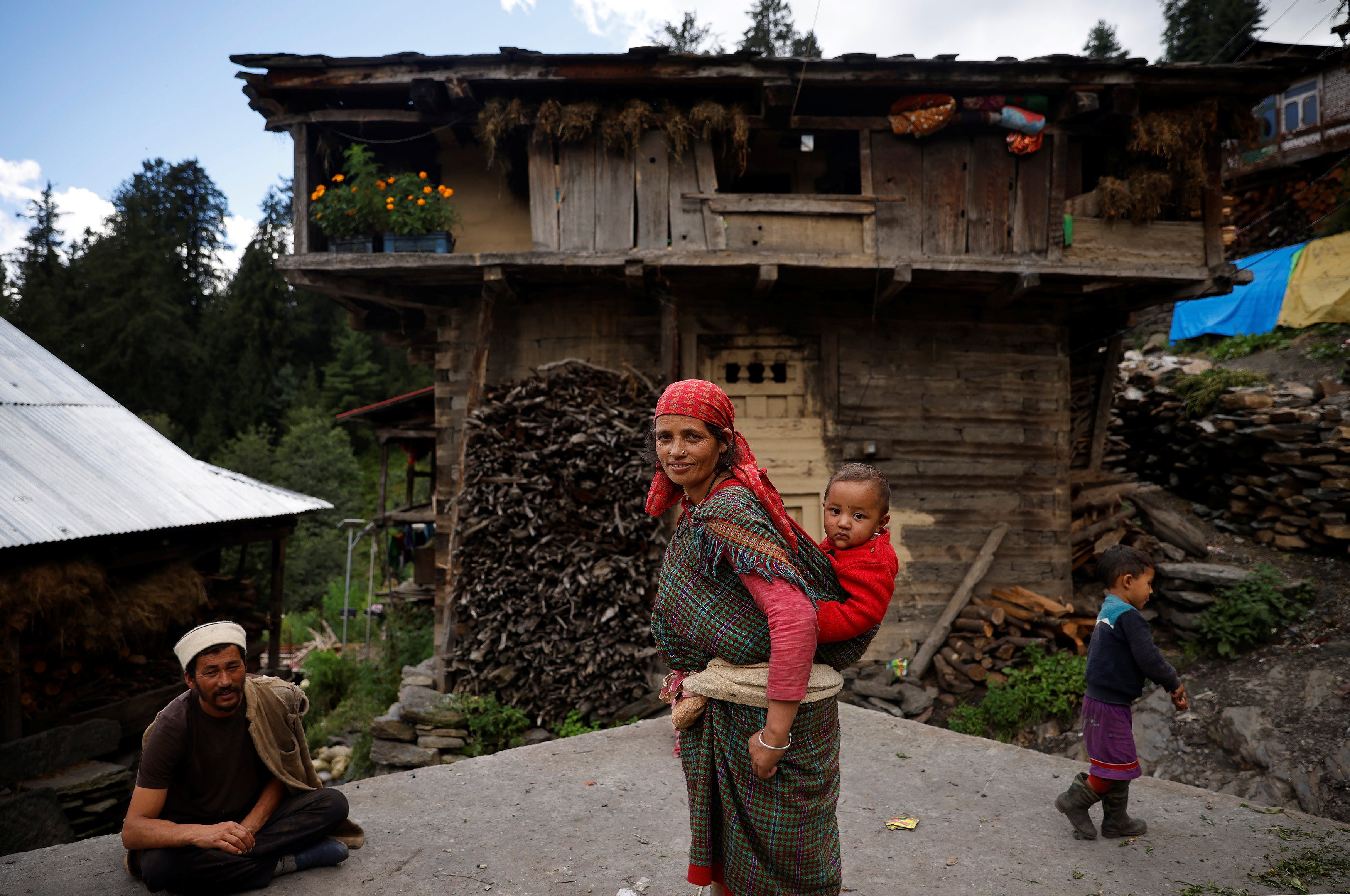 A family stands outside their house in Malana