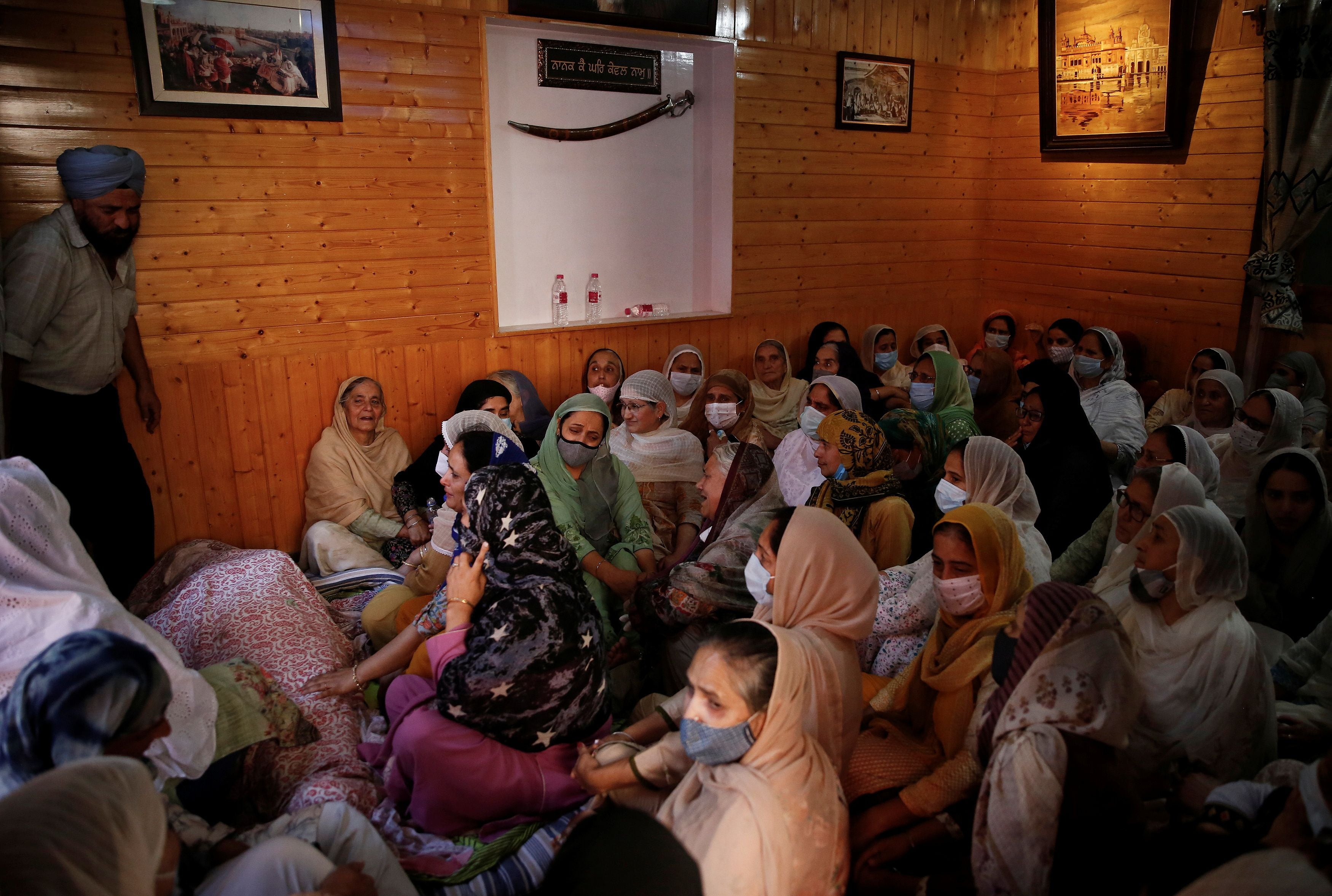 Relatives mourn around the body of Supinder Kour, a school teacher, who was shot and killed by suspected militants in Srinagar