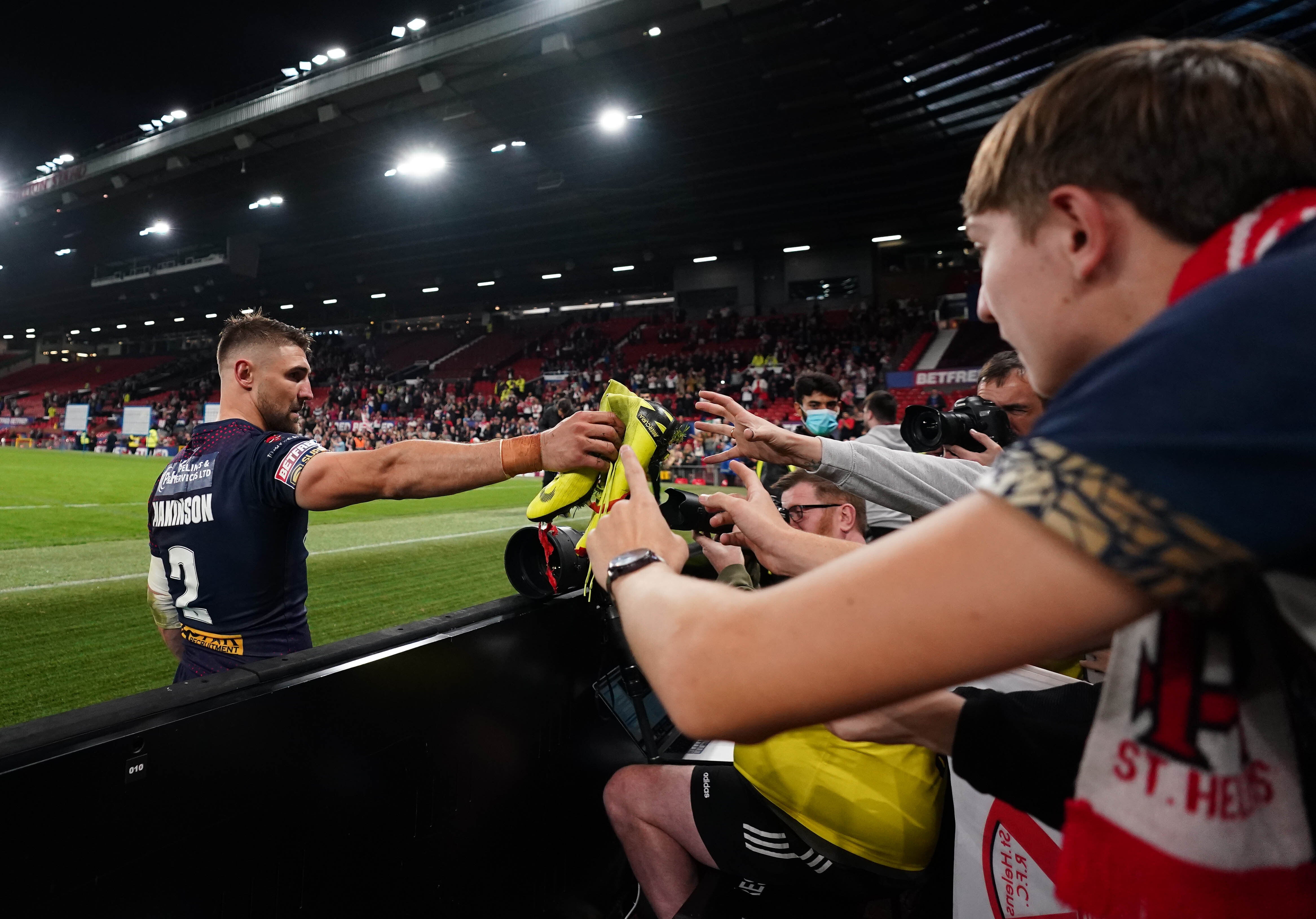 St Helens’ Tommy Makinson gives his boots to a fan (Zac Goodwin/PA)