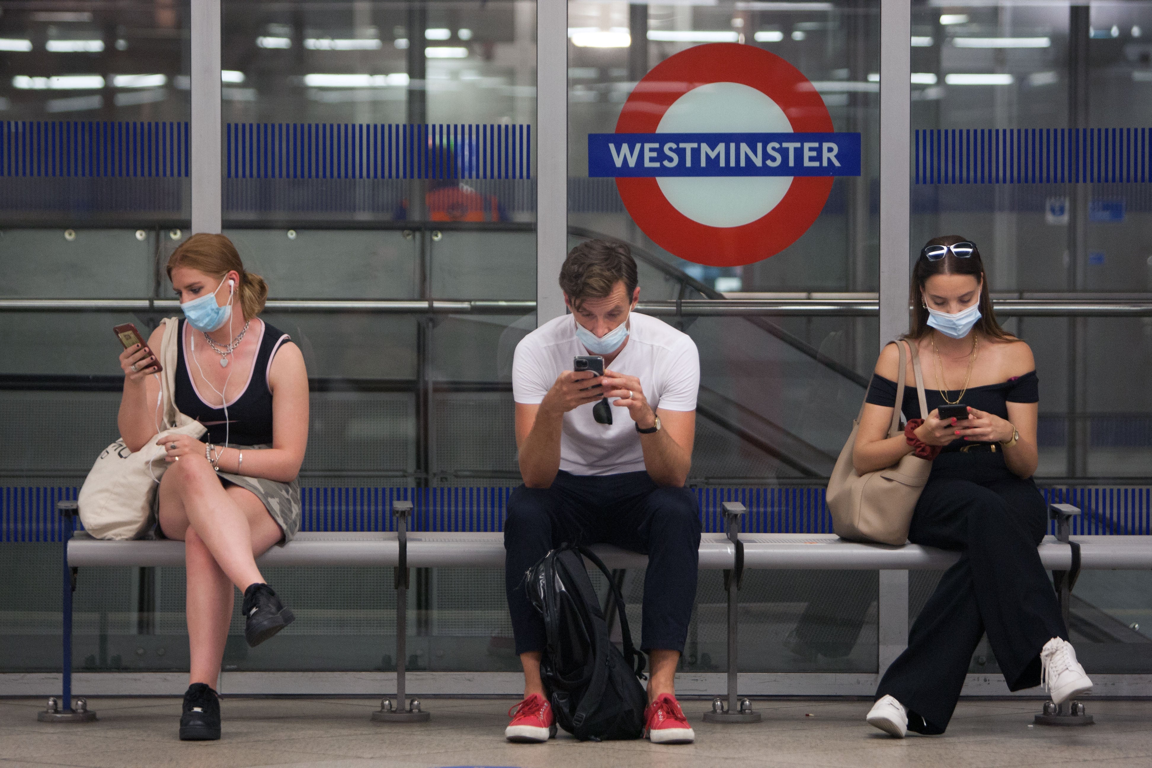 Commuters wait for a tube on the London Underground in July this year