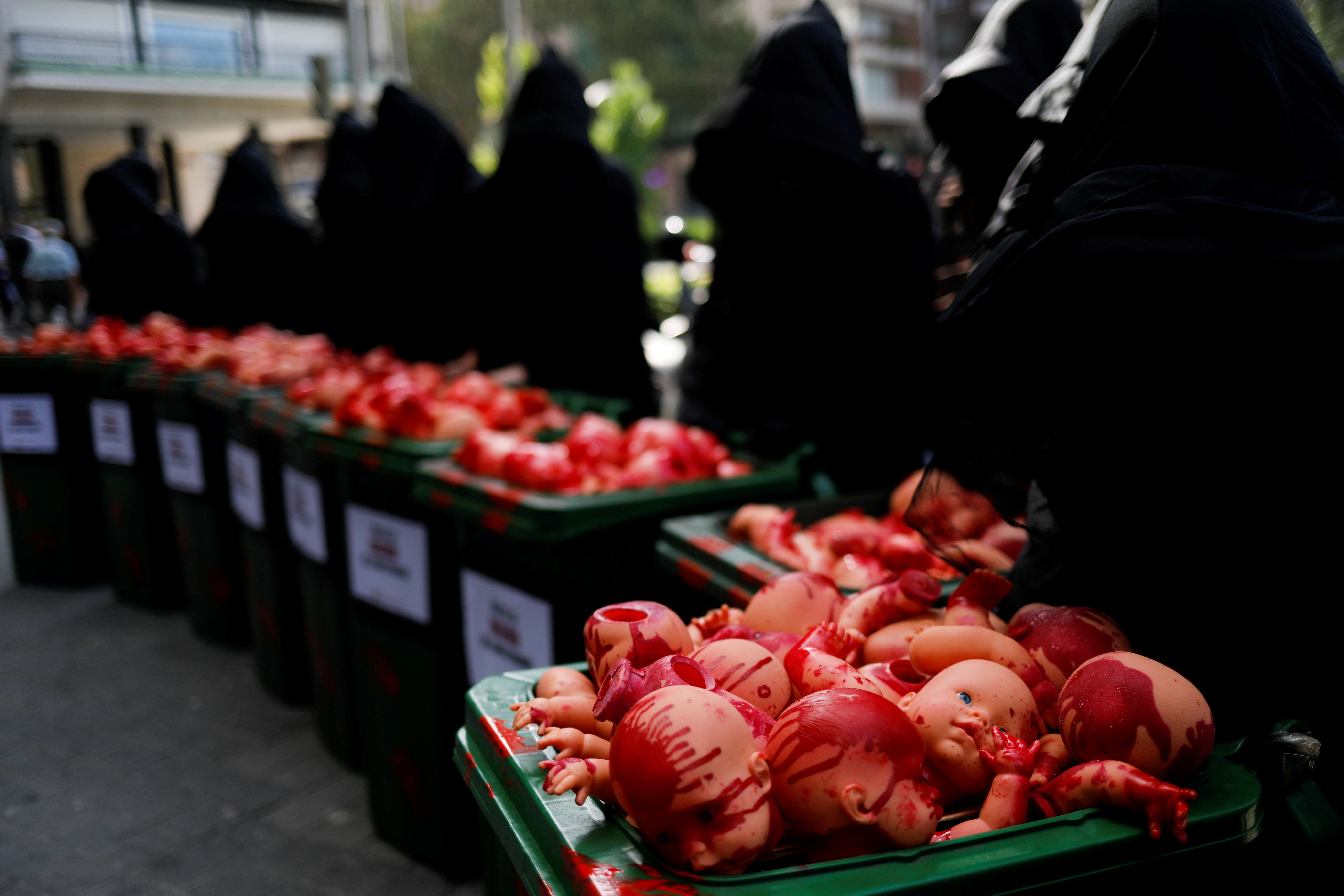 Anti-abortion supporters, dressed as Death and carrying baby dolls covered in fake blood, protest outside the Constitutional Court in Madrid