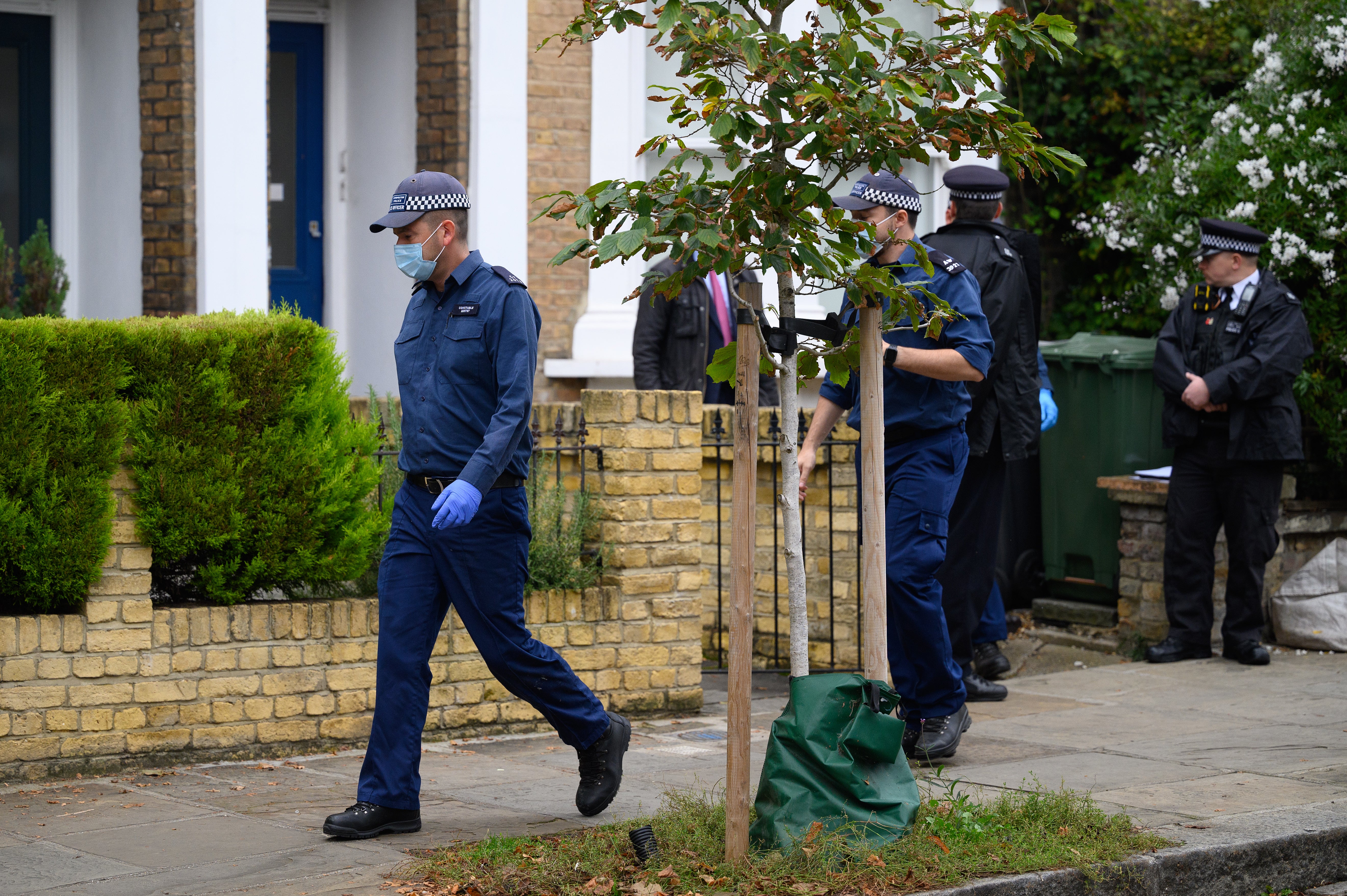 Members of a police search team leave the residence in Kentish Town