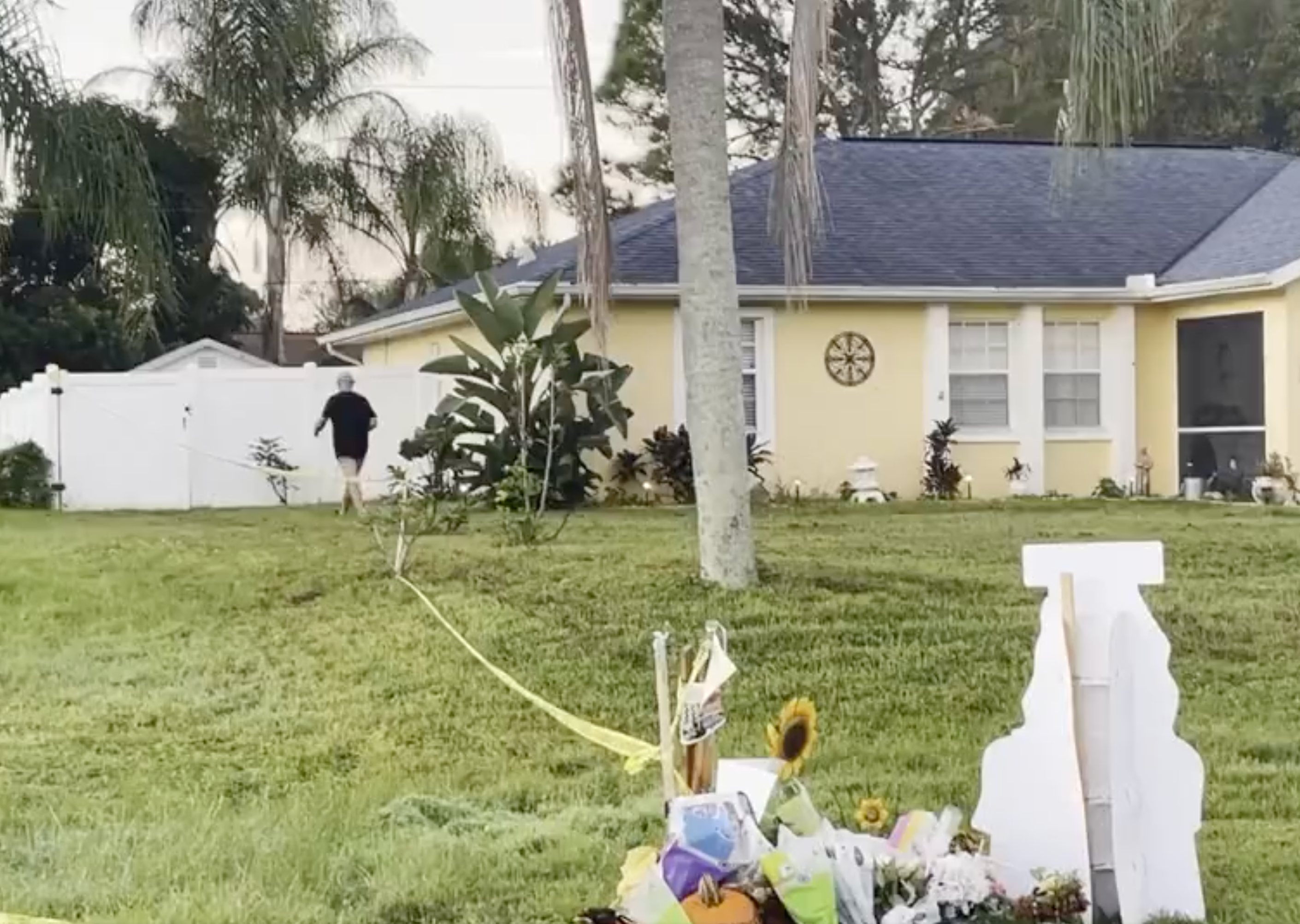 Chris Laundrie carries off a protest sign that had been planted in his lawn in North Port, Florida