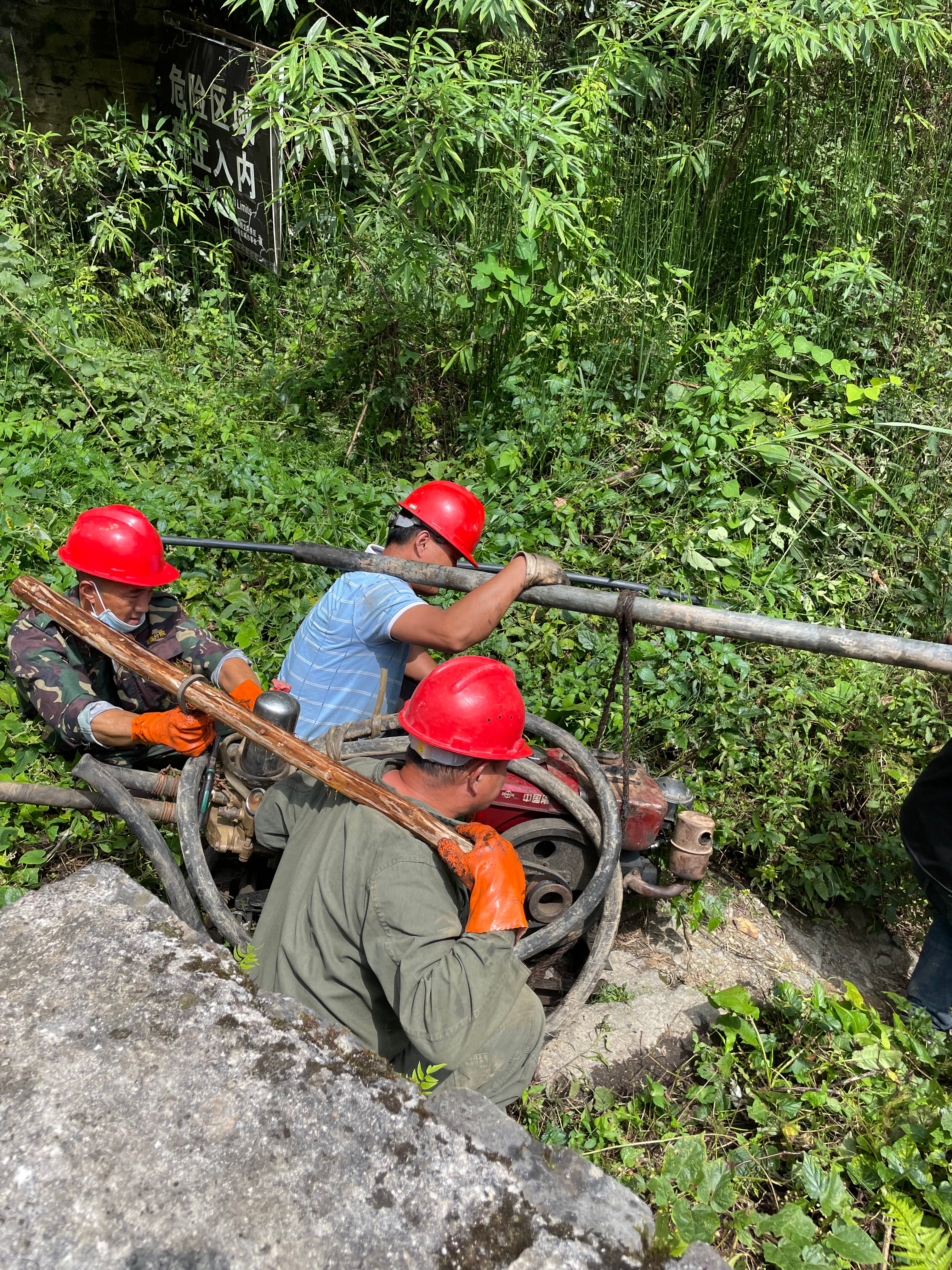 A repaired pump is taken back into a cave in order to pump out spring water