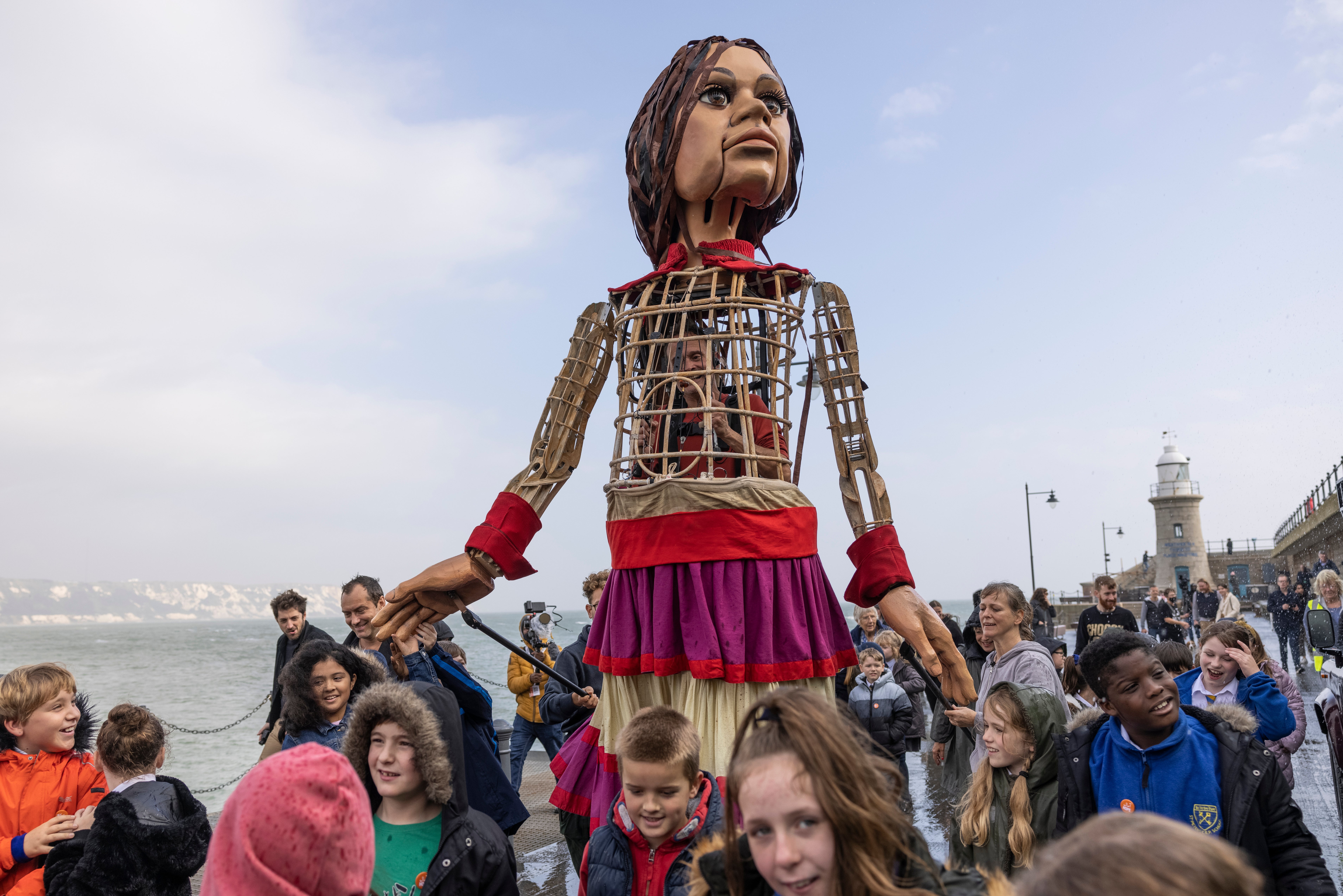 Little Amal was greeted by Jude Law and a group of schoolchildren in Folkestone