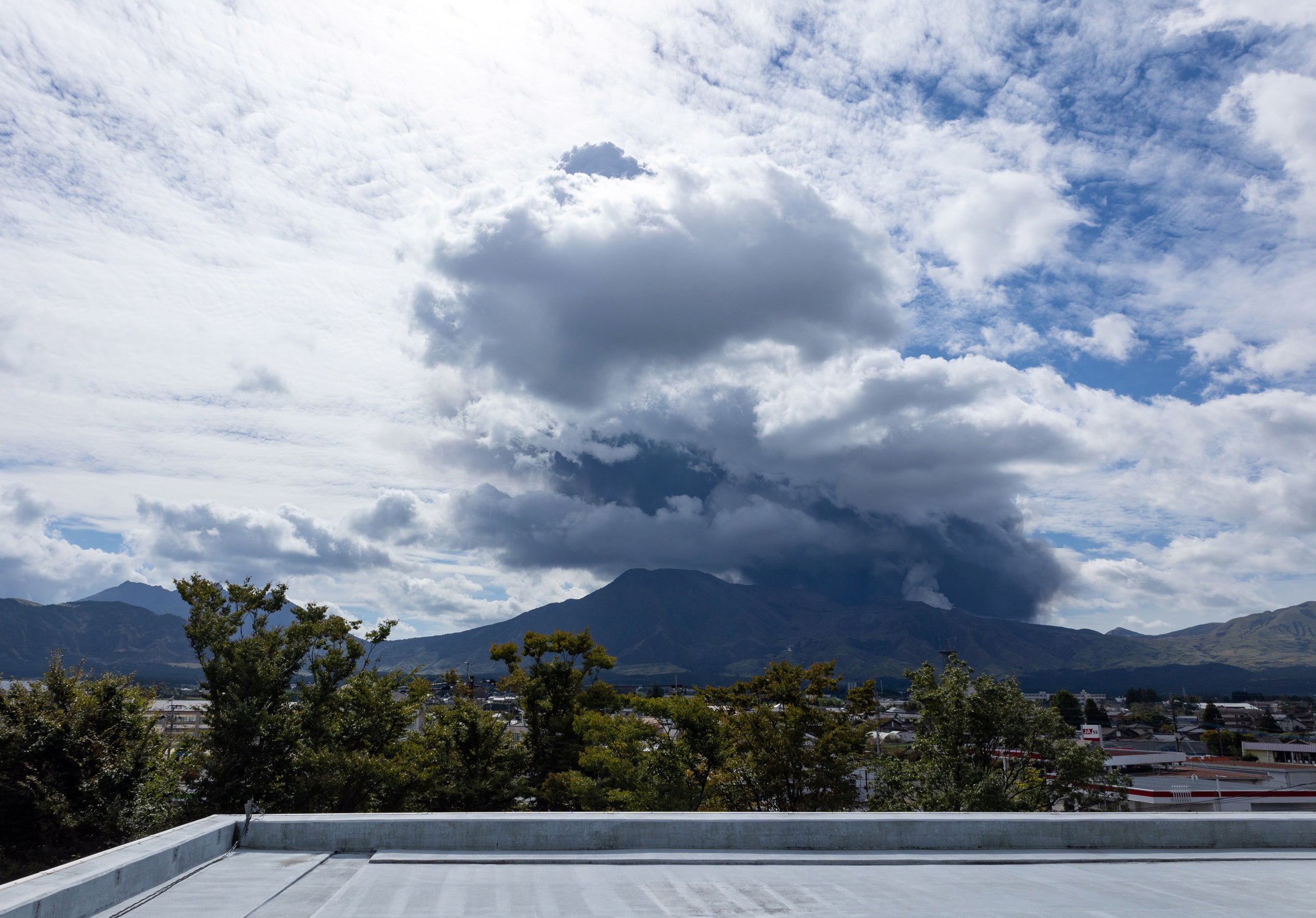 Black clouds form in the background following an eruption of Mount Aso in the Kumamoto prefecture in southwestern Japan on 20 October 2021