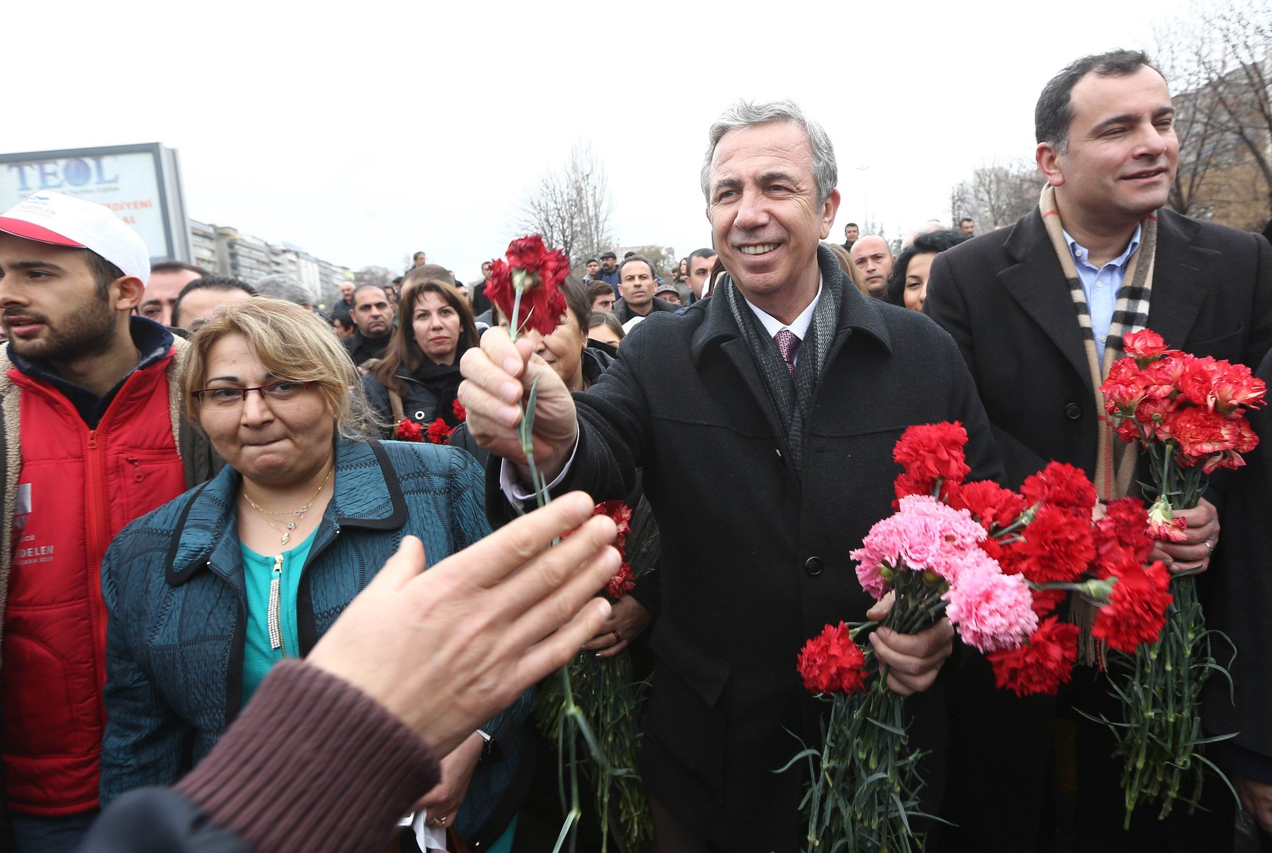 Yavas offers carnations to supporters during a campaign rally in Ankara