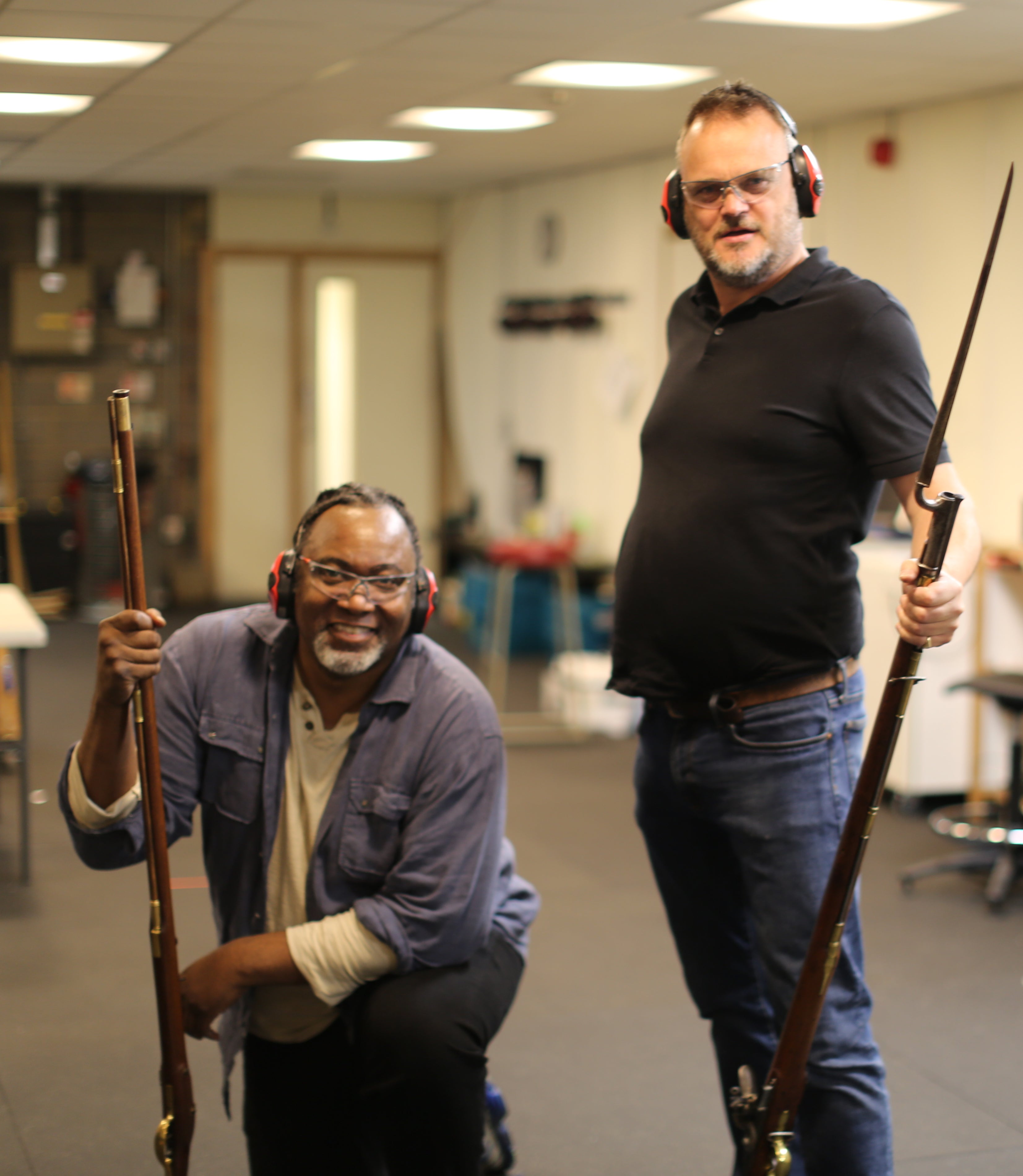 Murray and US comedian Reginald D Hunter hold antique guns at a firing range