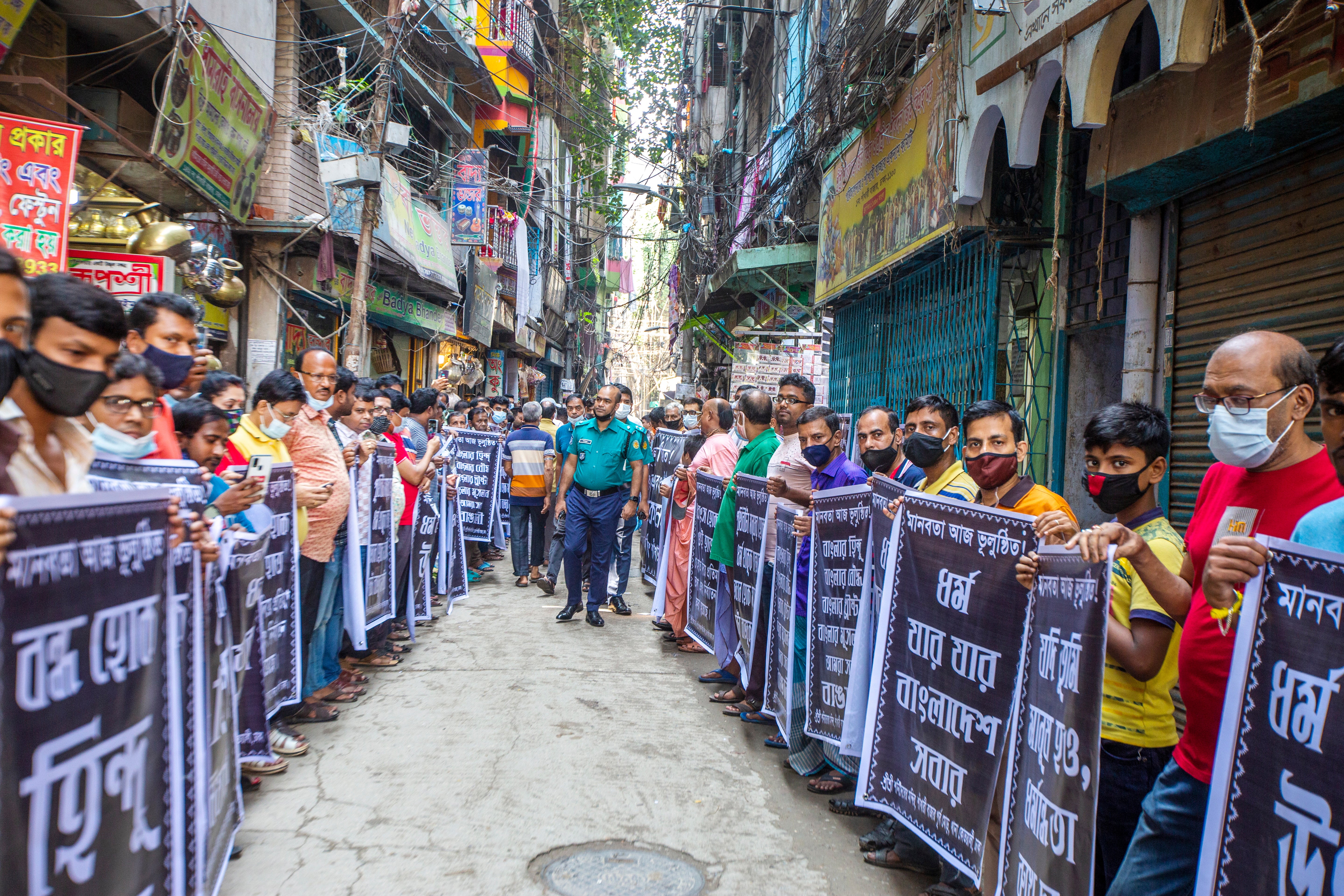 Bangladeshi Hindu community members hold banners as they take part in a protest in front of the Sri Sri Shani Dev Temple at Shankhari Bazar in Dhaka, Bangladesh, 21 October 2021. According to the police at least six people died in recent attacks on the Hindu community, temples, shops and houses in several districts in Bangladesh EPA/MONIRUL ALAM