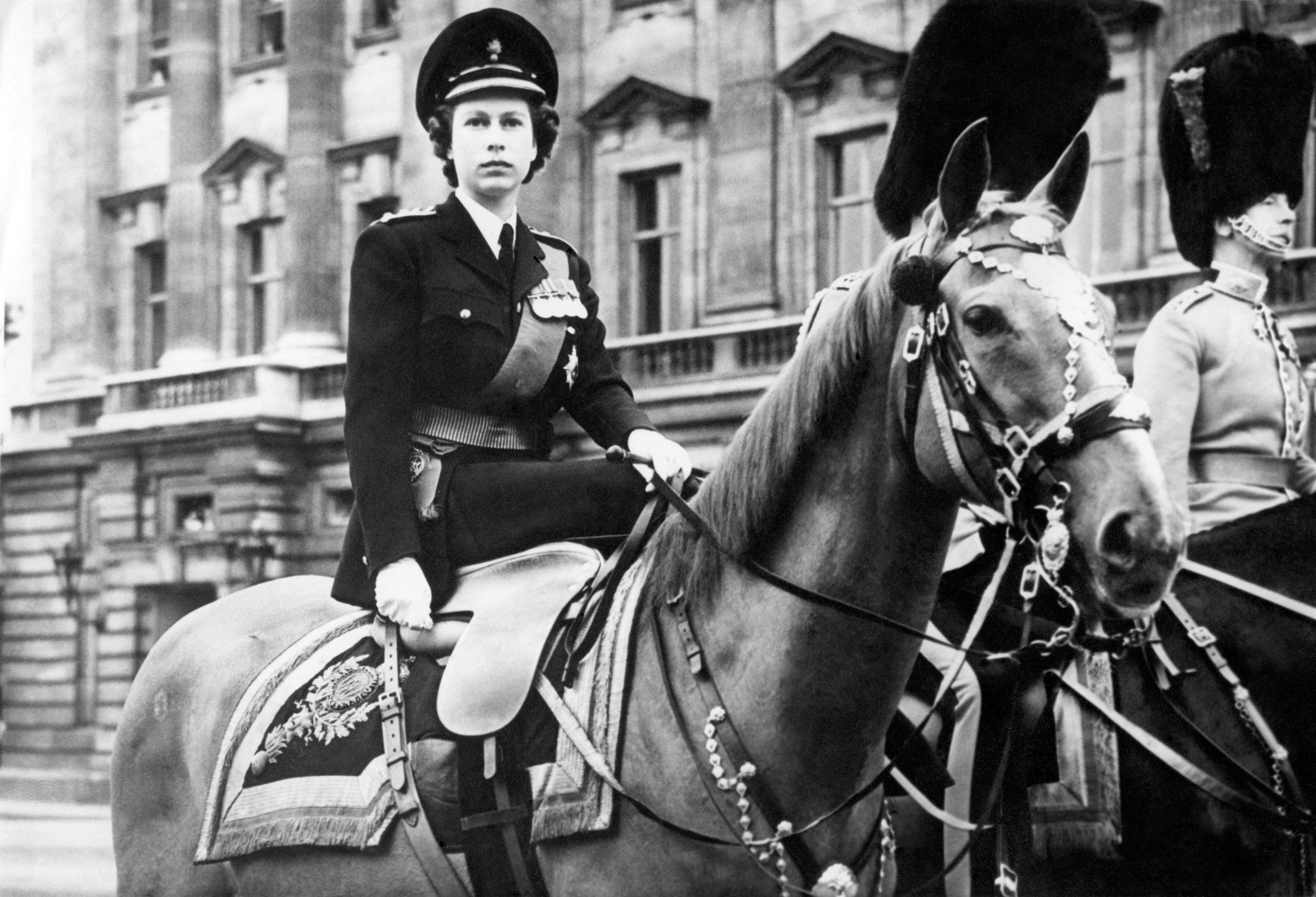 Princess Elizabeth in 1949, as Colonel of the Grenadier Guards, sits atop Winston, a police horse, in the forecourt of Buckingham Palace, during the Trooping fo the Colour to mark King George VI’s 53rd birthday