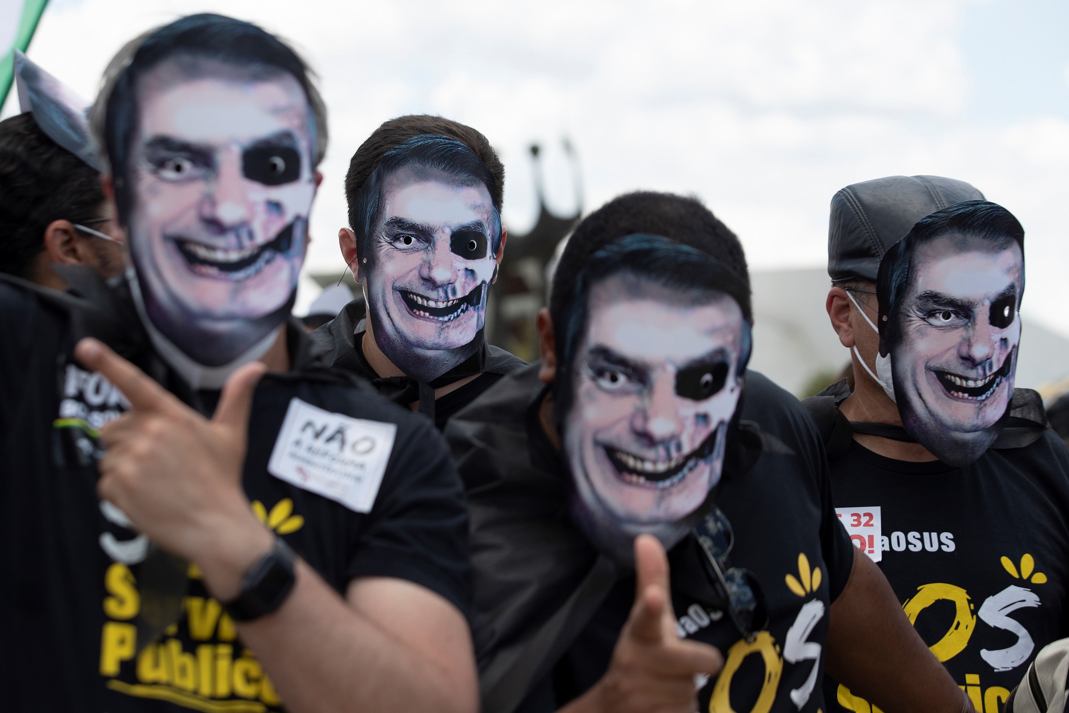 Protesters in Brasilia wear masks representing President Bolsonaro painted as a skull during a demonstration rejecting the government's handling of the pandemic