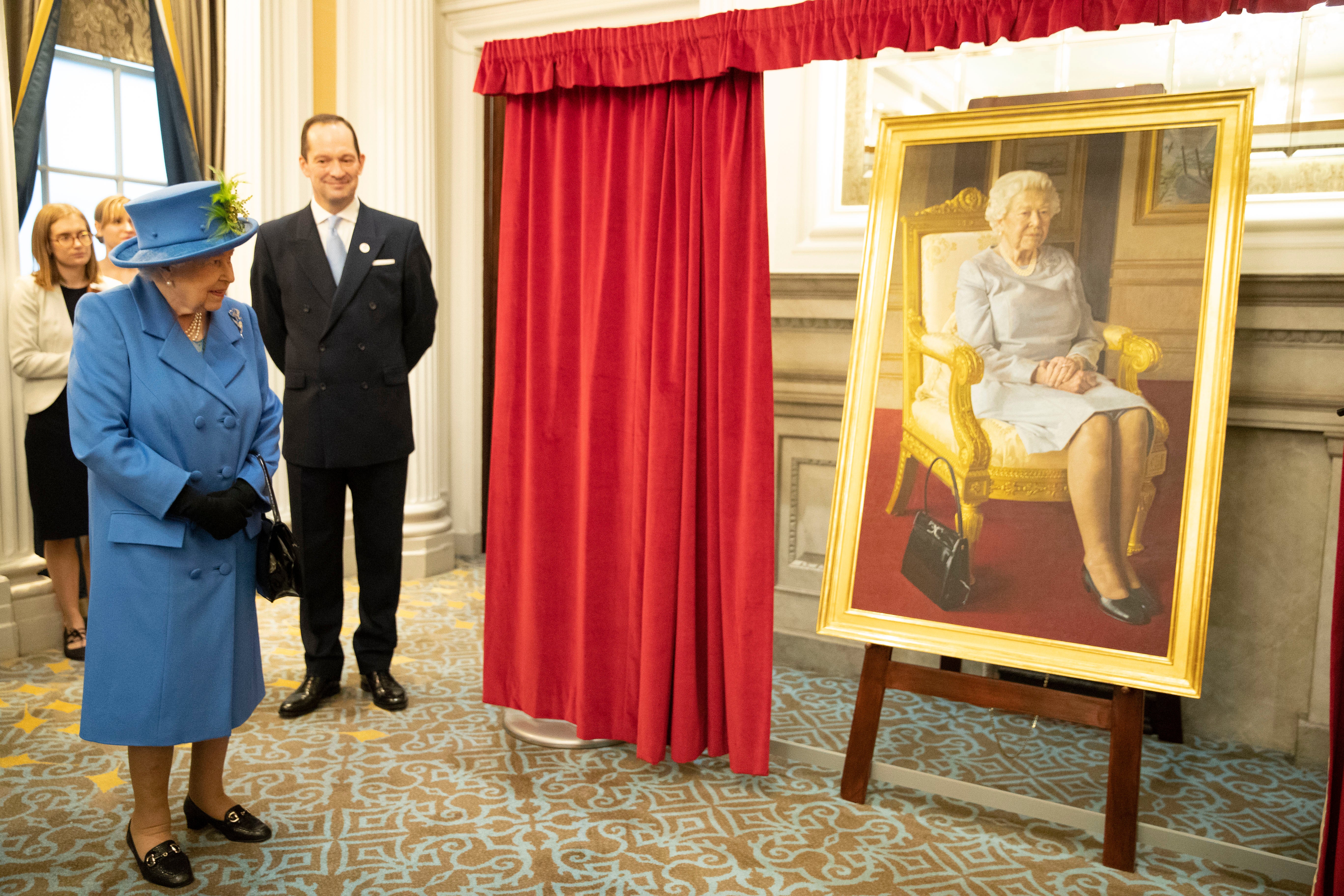 Queen Elizabeth II views a new portrait depicting Her Majesty painted by BP Portrait Award 2017 winner, Benjamin Sullivan, the portrait commissioned to celebrate 100 years of the RAF Club