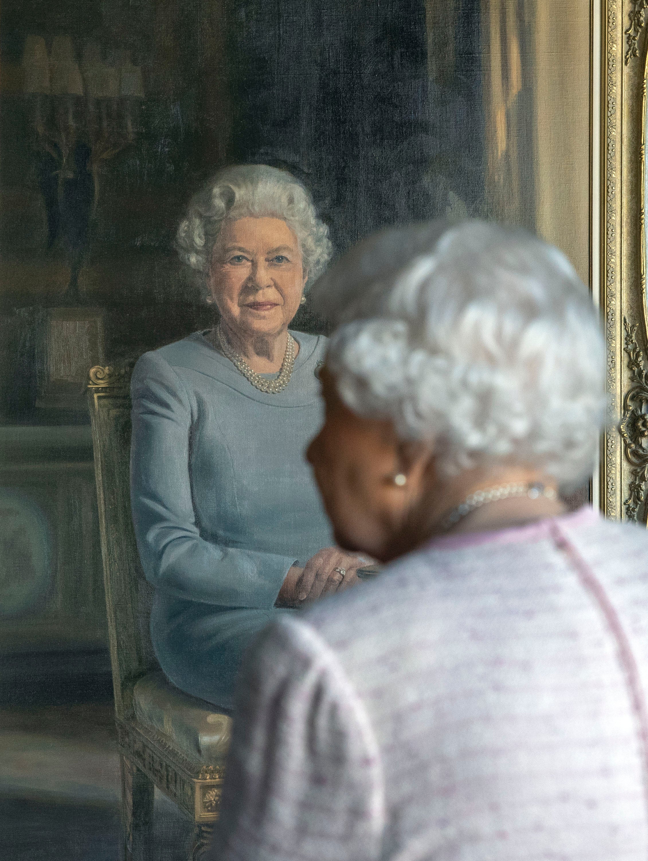 Queen Elizabeth II views her new portrait commissioned by the RAF Regiment to celebrate its 75th anniversary, in the White Drawing Room at Windsor Castle on November 30, 2018