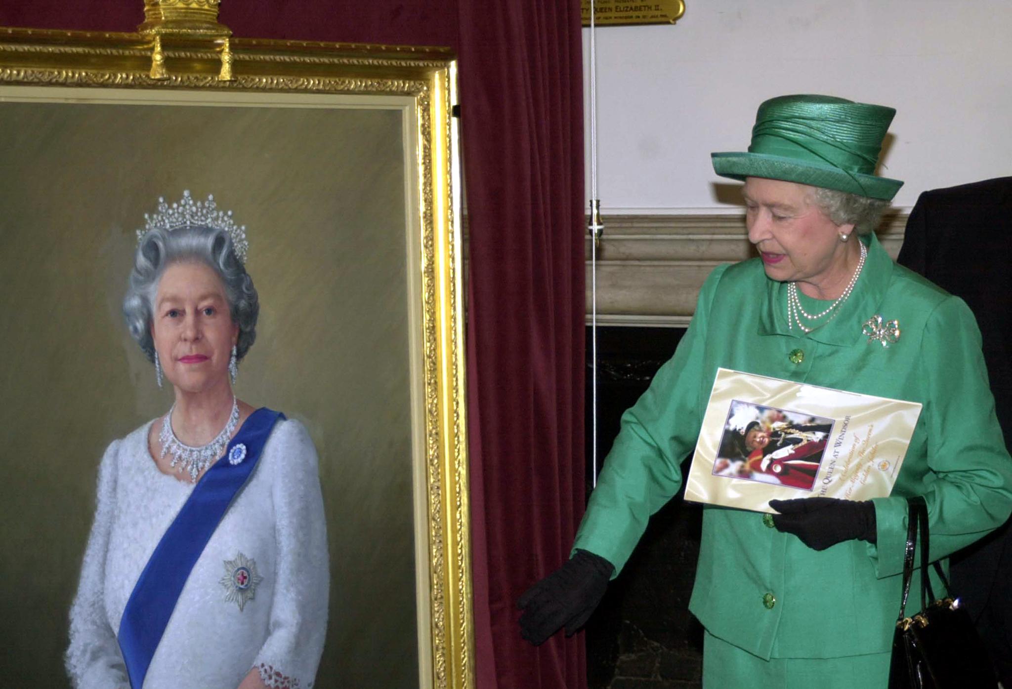 Queen Elizabeth II unveils a portrait of herself by artist Theodore Ramos at the Guildhall in Windsor, 03 June 2002, to mark her Golden Jubilee