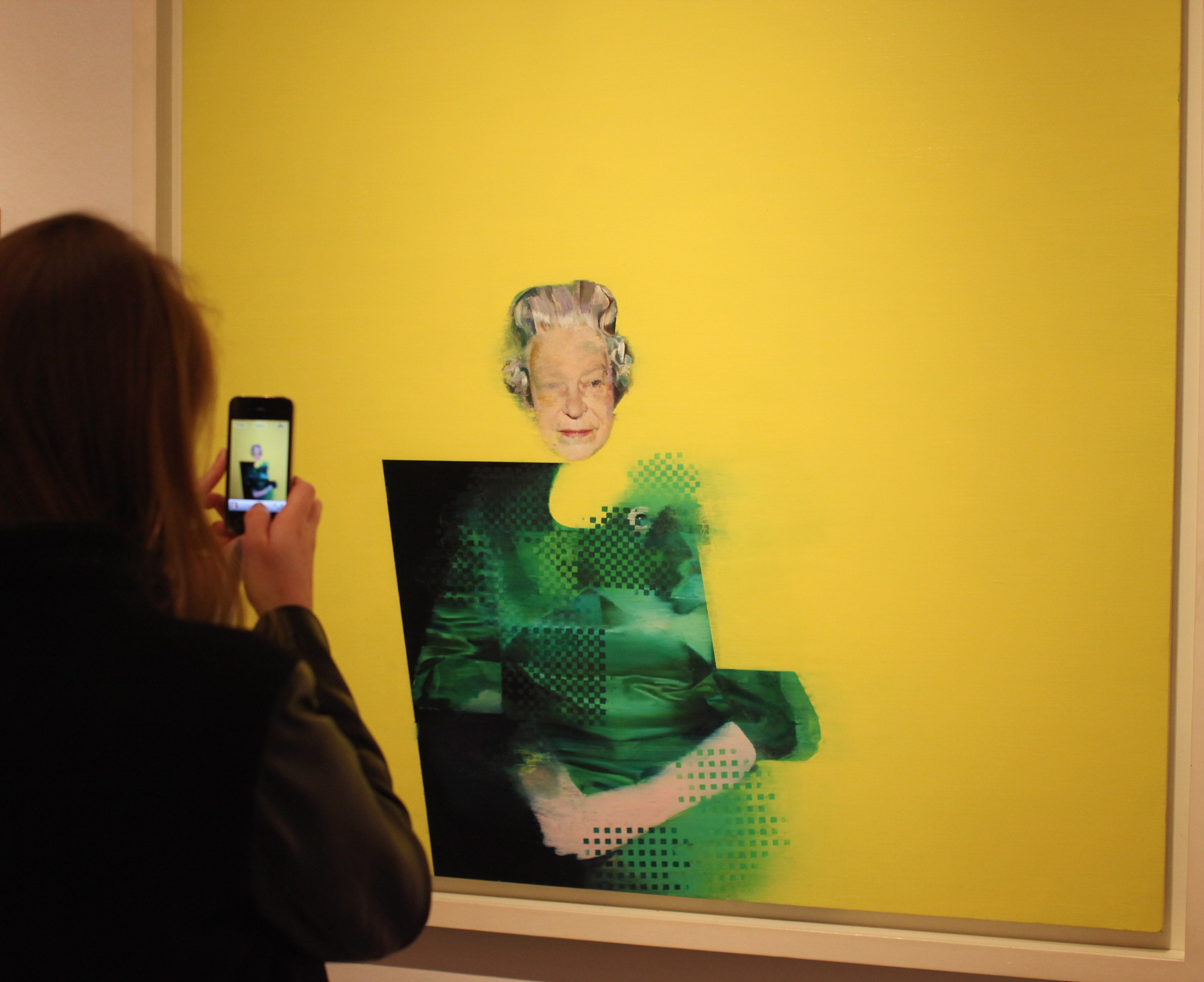 A woman photographs a painting of Her Majesty Queen Elizabeth II by artist Justin Mortimer entitled 'The Queen' in the National Portrait Gallery's exhibition 'The Queen: Art & Image' on May 16, 2012 in London