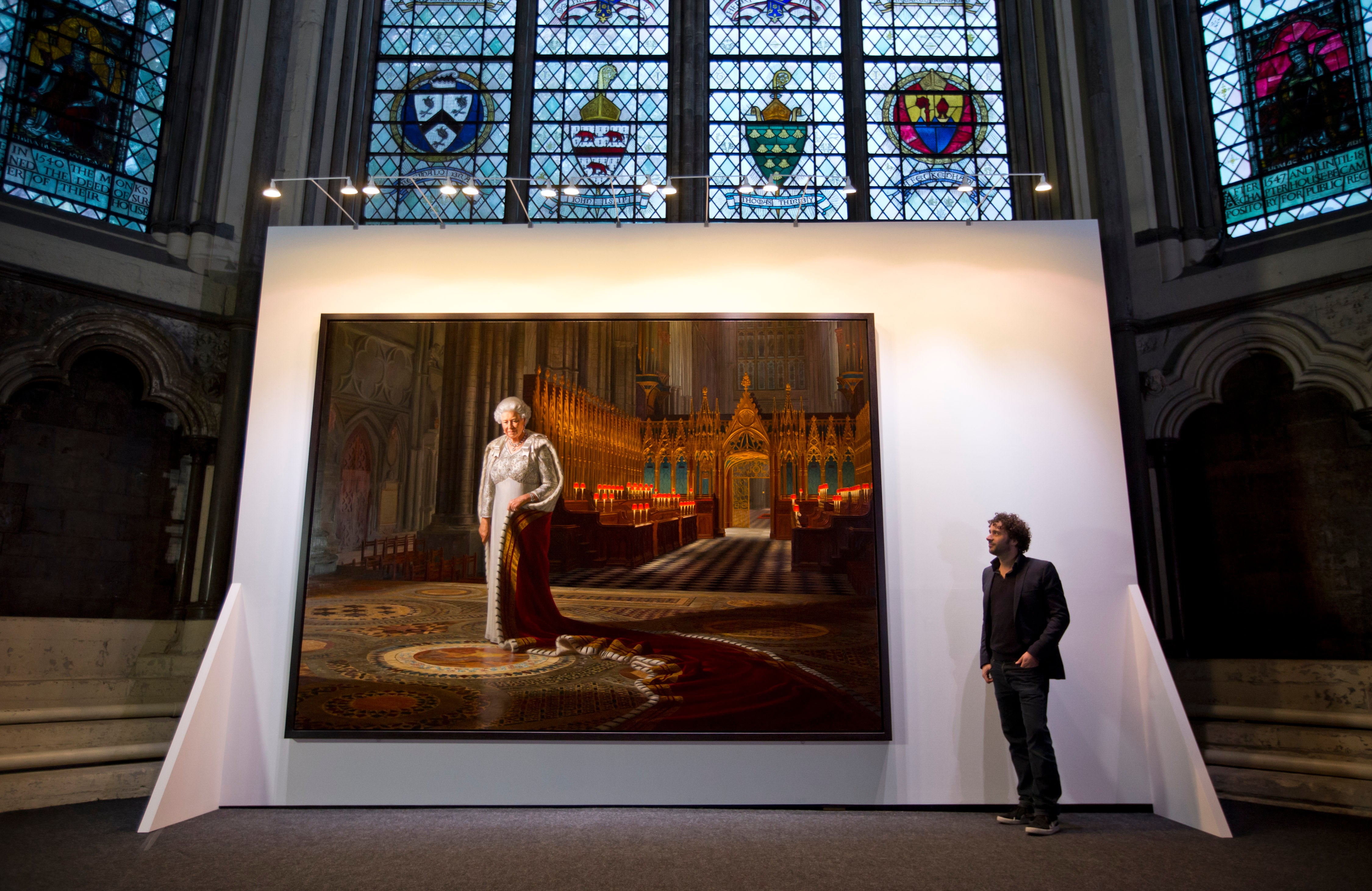 Artist Ralph Heimans stands beside his painting of Queen Elizabeth II inside the Chapter House at Westminster Abbey on May 17, 2013 in London, England