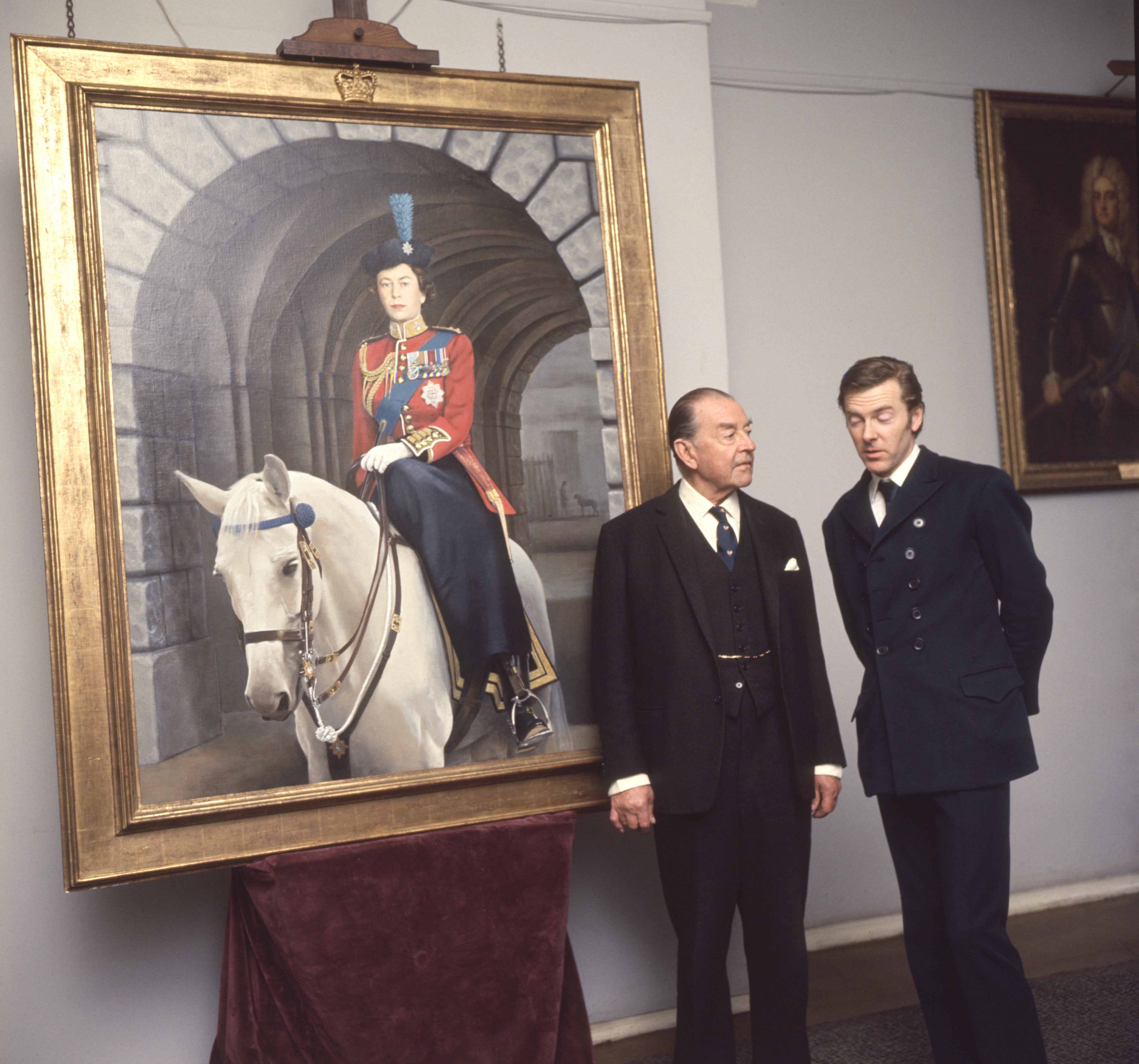 The new portrait of the Queen, by Timothy Whidborne, at Wellington Barracks, London. The artist is seen with Earl Alexander. The portrait shows the Queen wearing the uniform of Colonel-in-Chief Irish Guard, mounted on the Metropolitan Police horse 'Doctor'