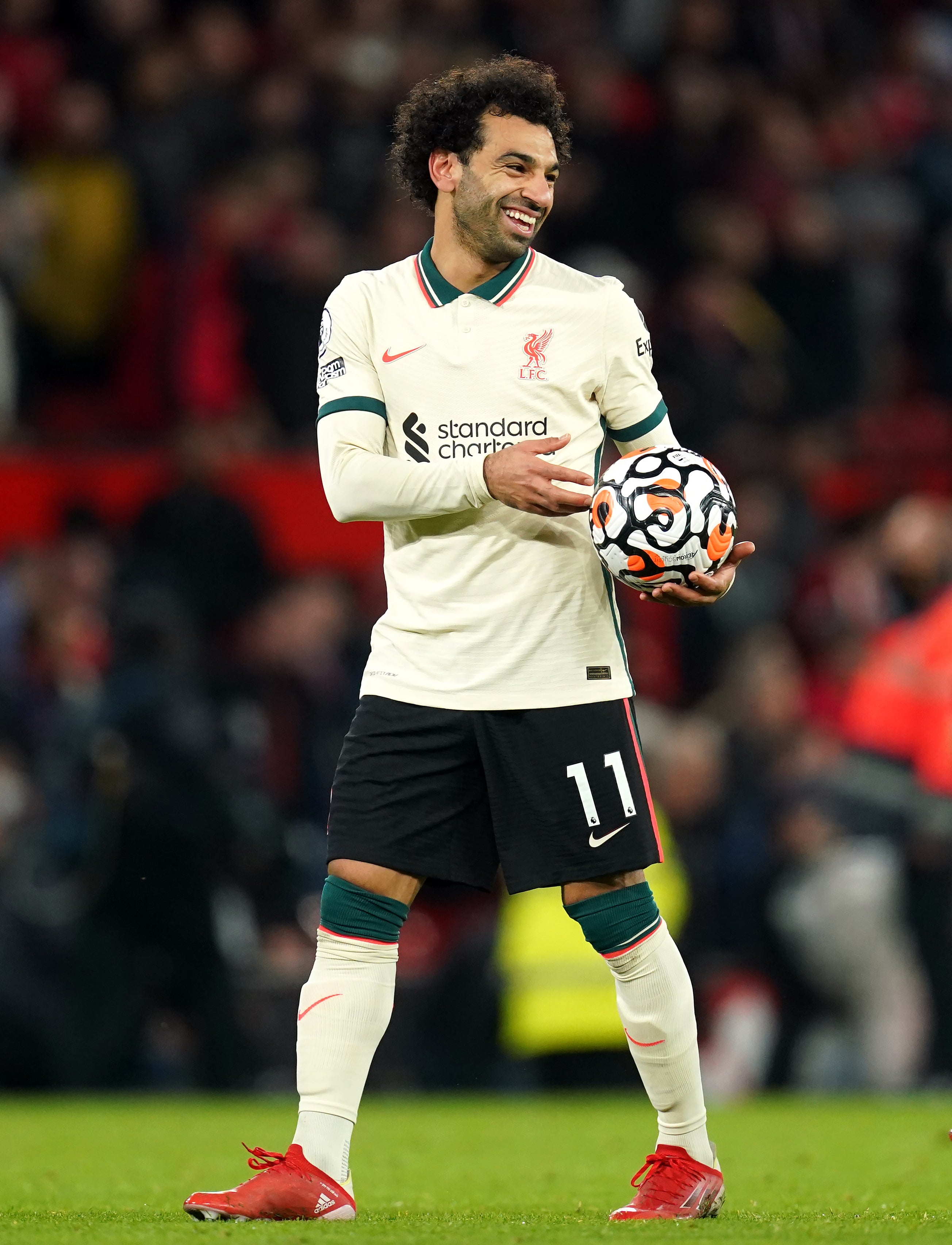 Liverpool hat-trick scorer Mohamed Salah celebrates with the match ball after the final whistle during the Premier League match at Old Trafford, Manchester (Martin Rickett/PA)