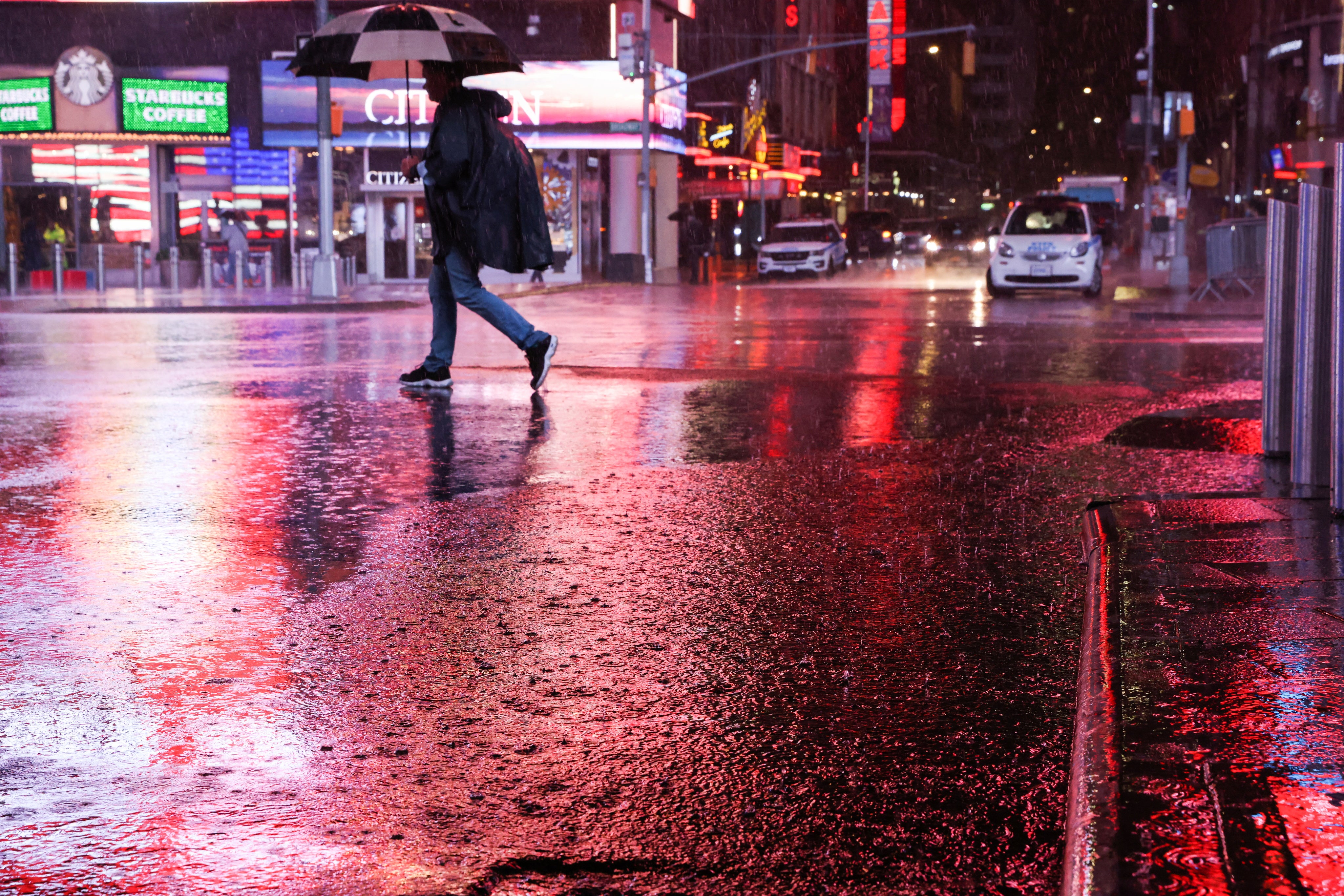 A person walks through Times Square during a nor'easter in New York on 26 October 2021.