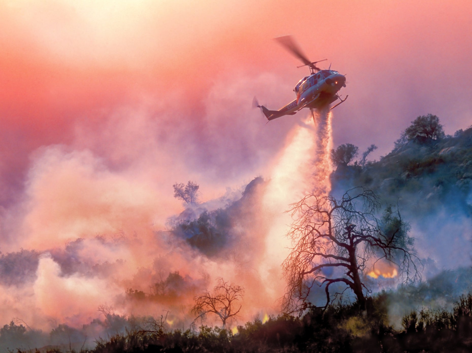 A helicopter dropping water on a California wildfire. Extreme weather is worsening with every fractional increase in warming, the scientists warned