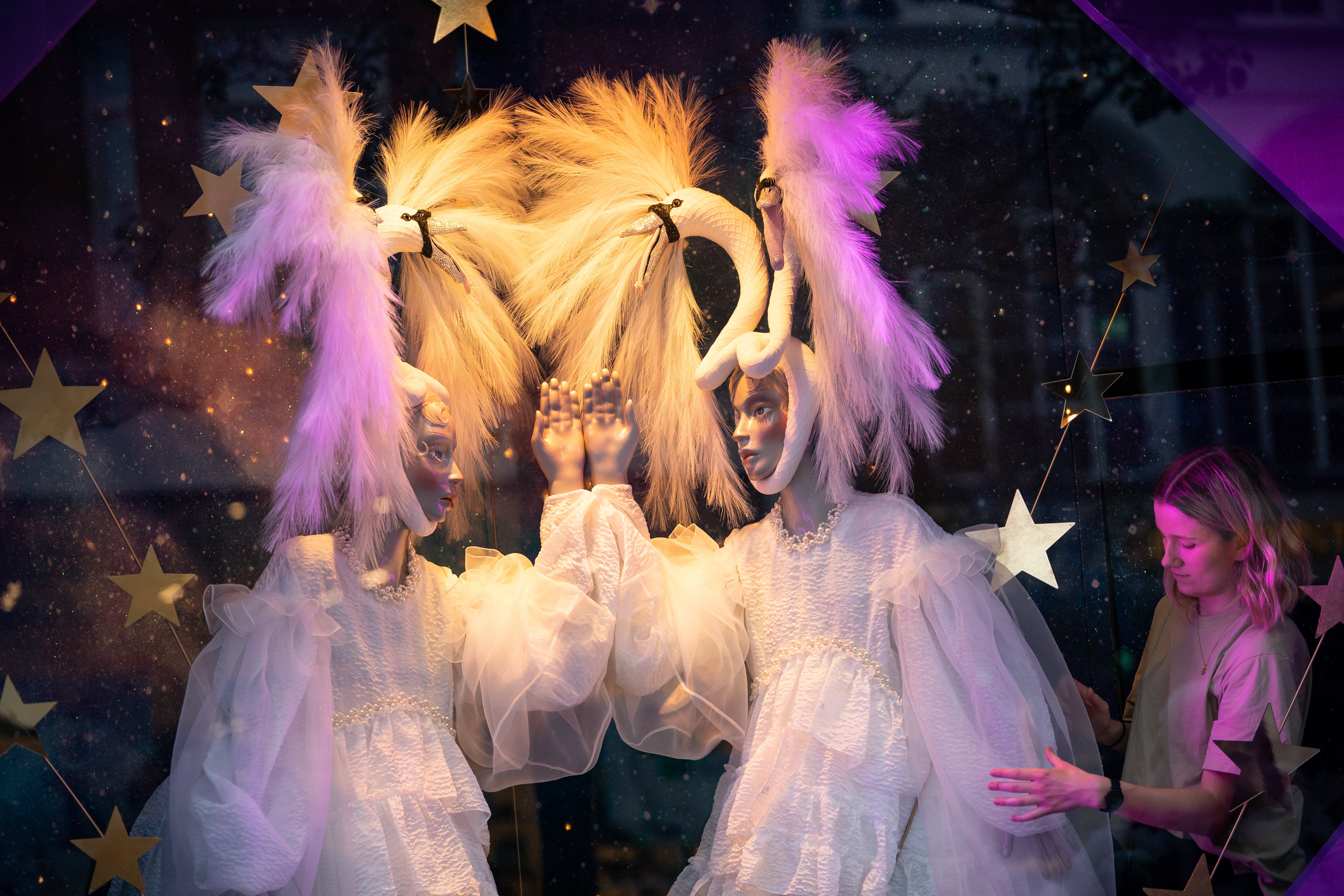 A shop assistant adjusts a window display at Selfridges in London as the department store unveils its 2021 Christmas campaign (Aaron Chown/PA)