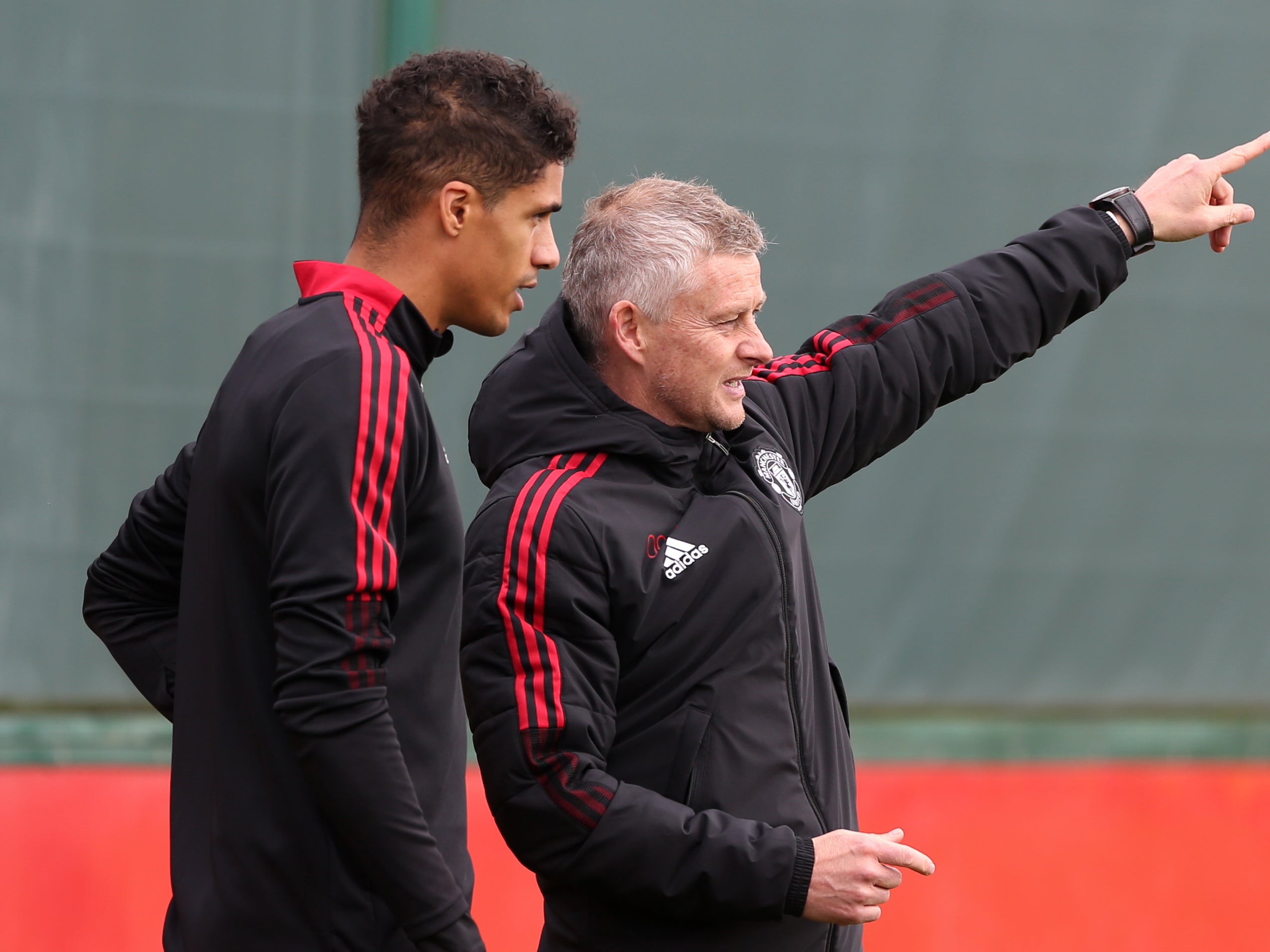 Manchester United manager Ole Gunnar Solskjaer with Raphael Varane in training