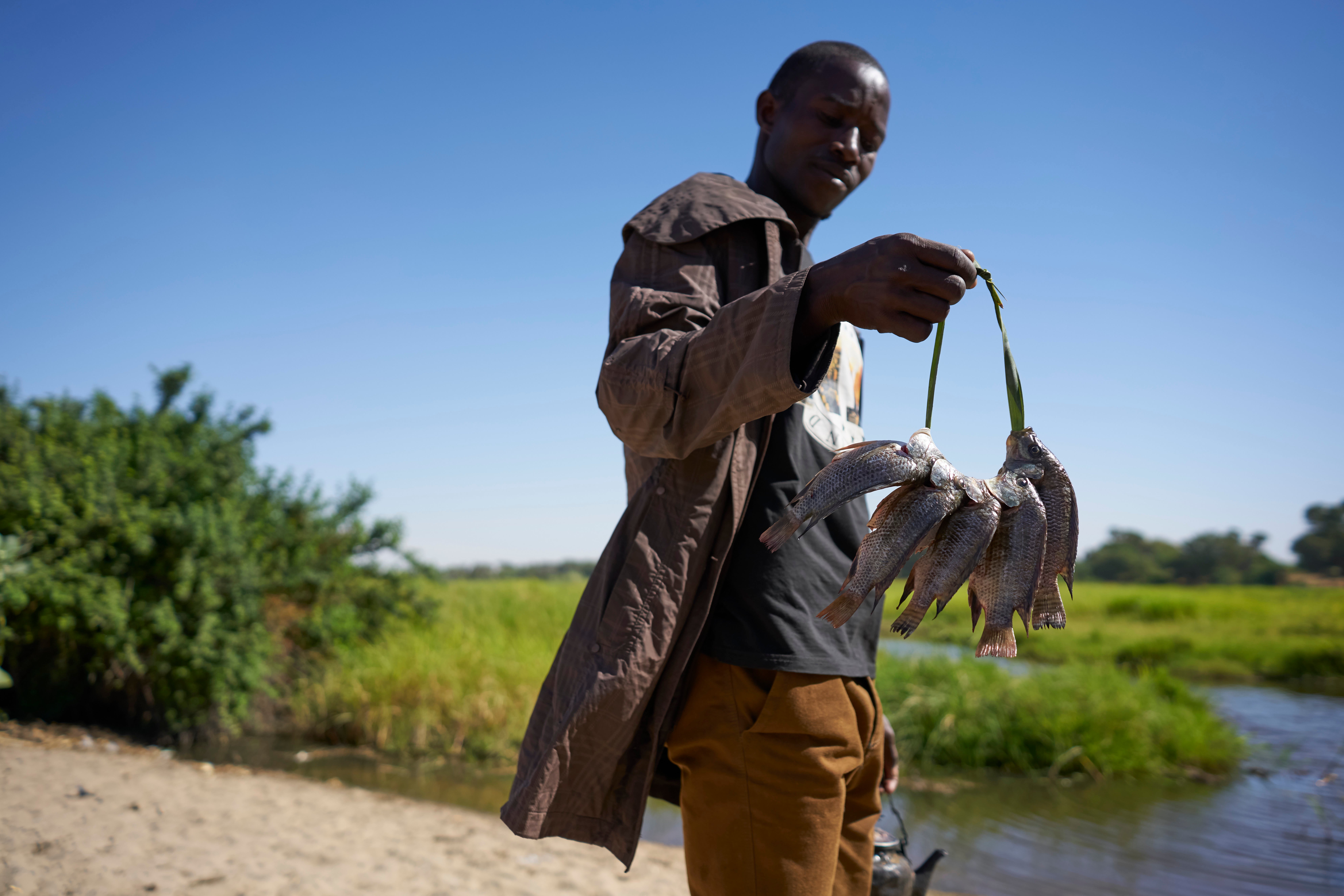 A Chadian fisherman shows of his catch on the banks of Lake Chad