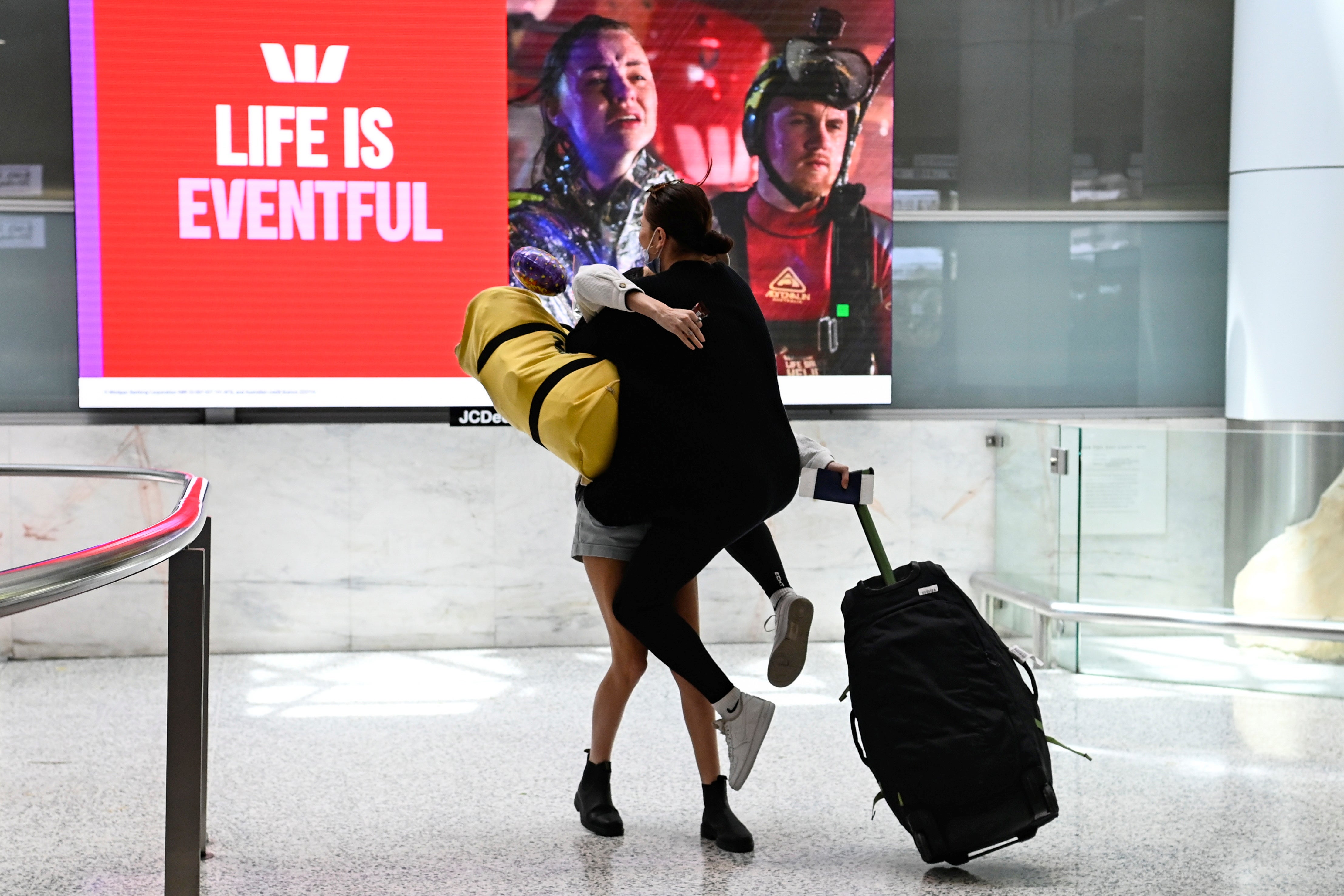 An overjoyed passenger greets his loved one at the airport