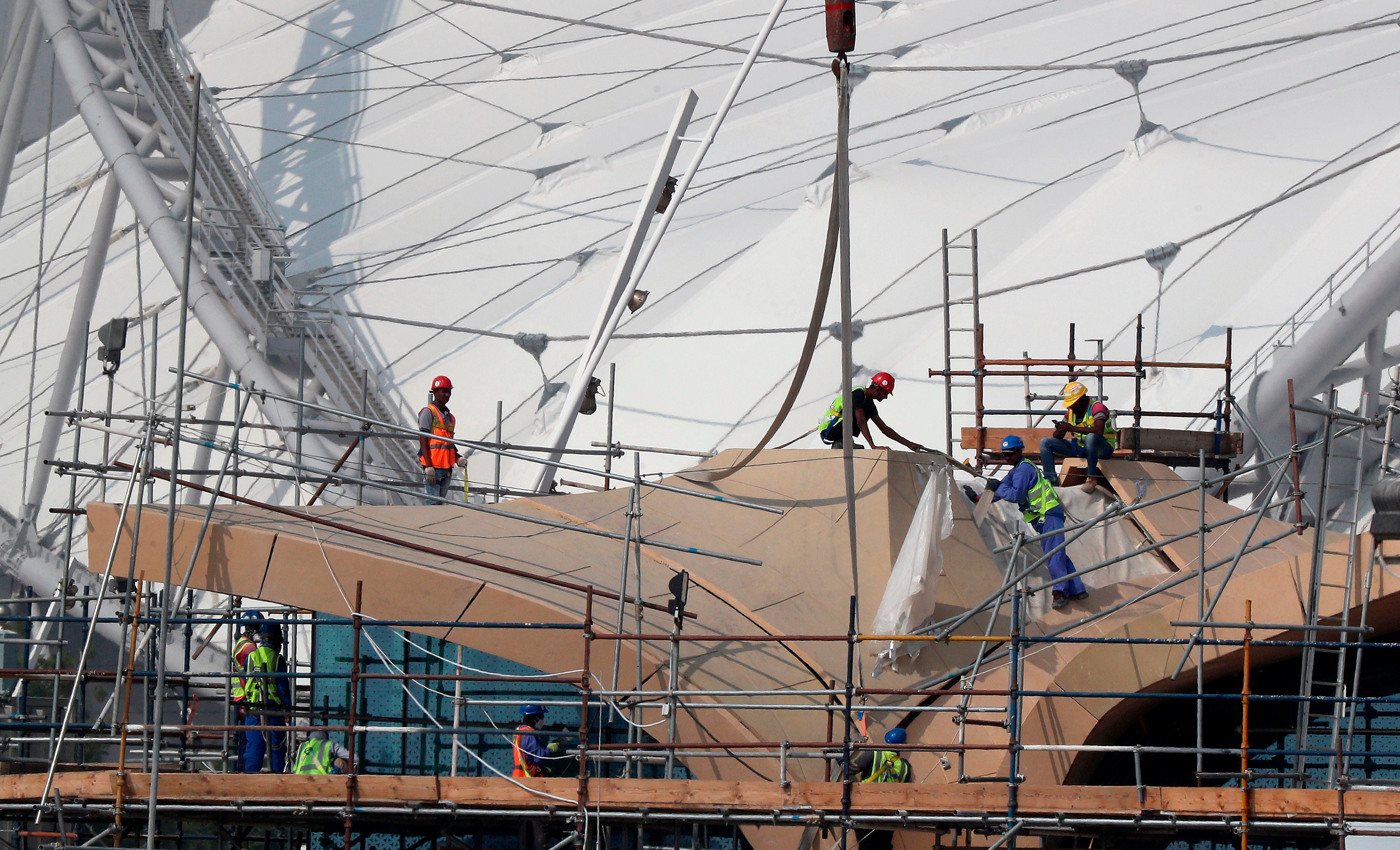 Workers are pictured on scaffolding at the Khalifa International Stadium in Doha on November 2018