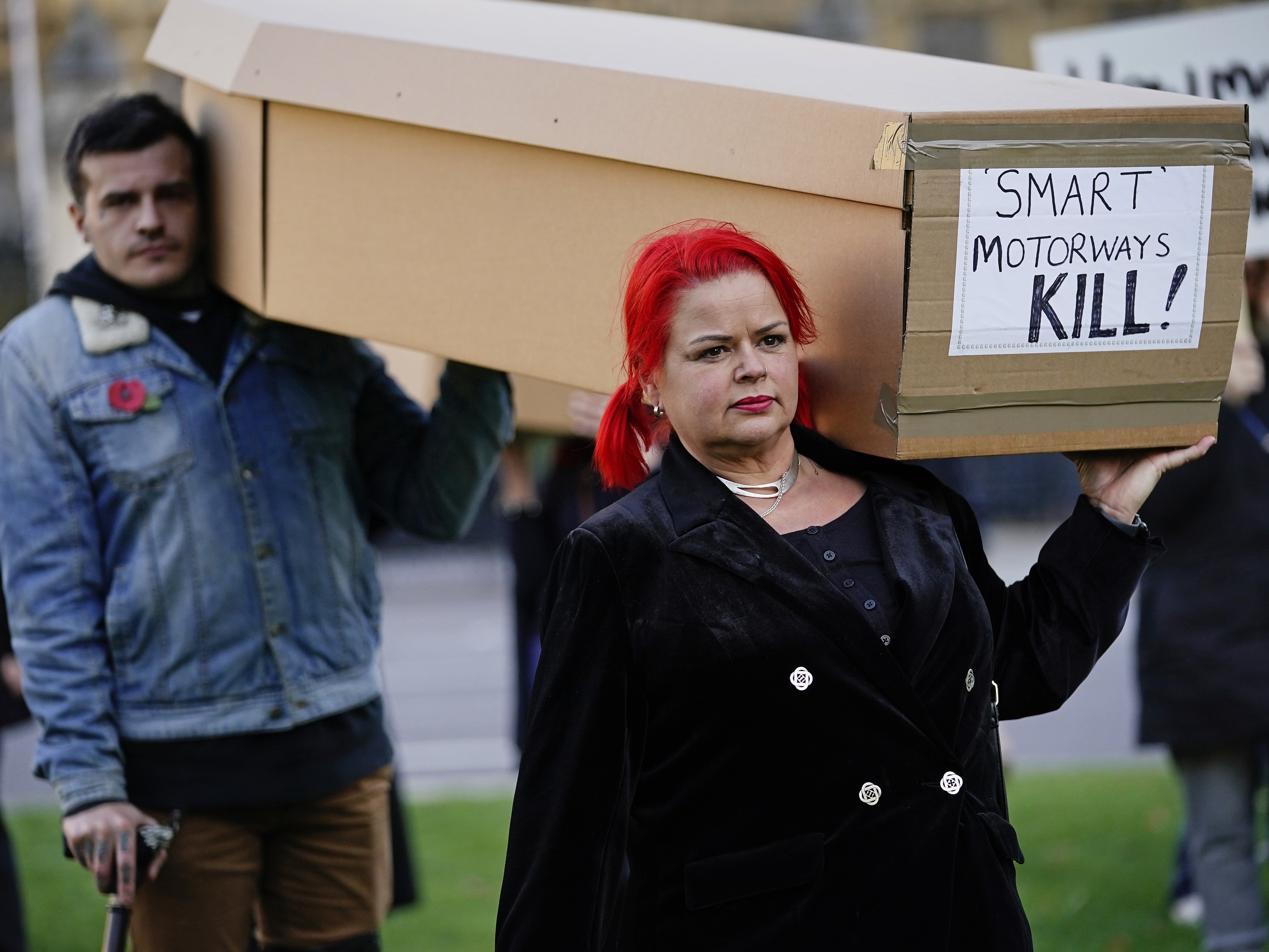 Demonstrators protesting against smart motorways march with coffins across Westminster Bridge to Parliament Square in London