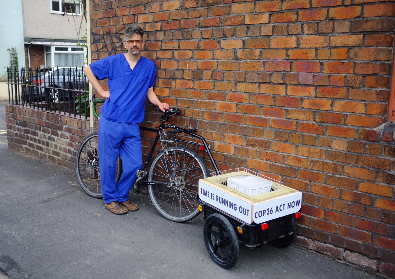 Jet McDonald is transporting a block of ice with him as he cycles to represent the melting ice caps