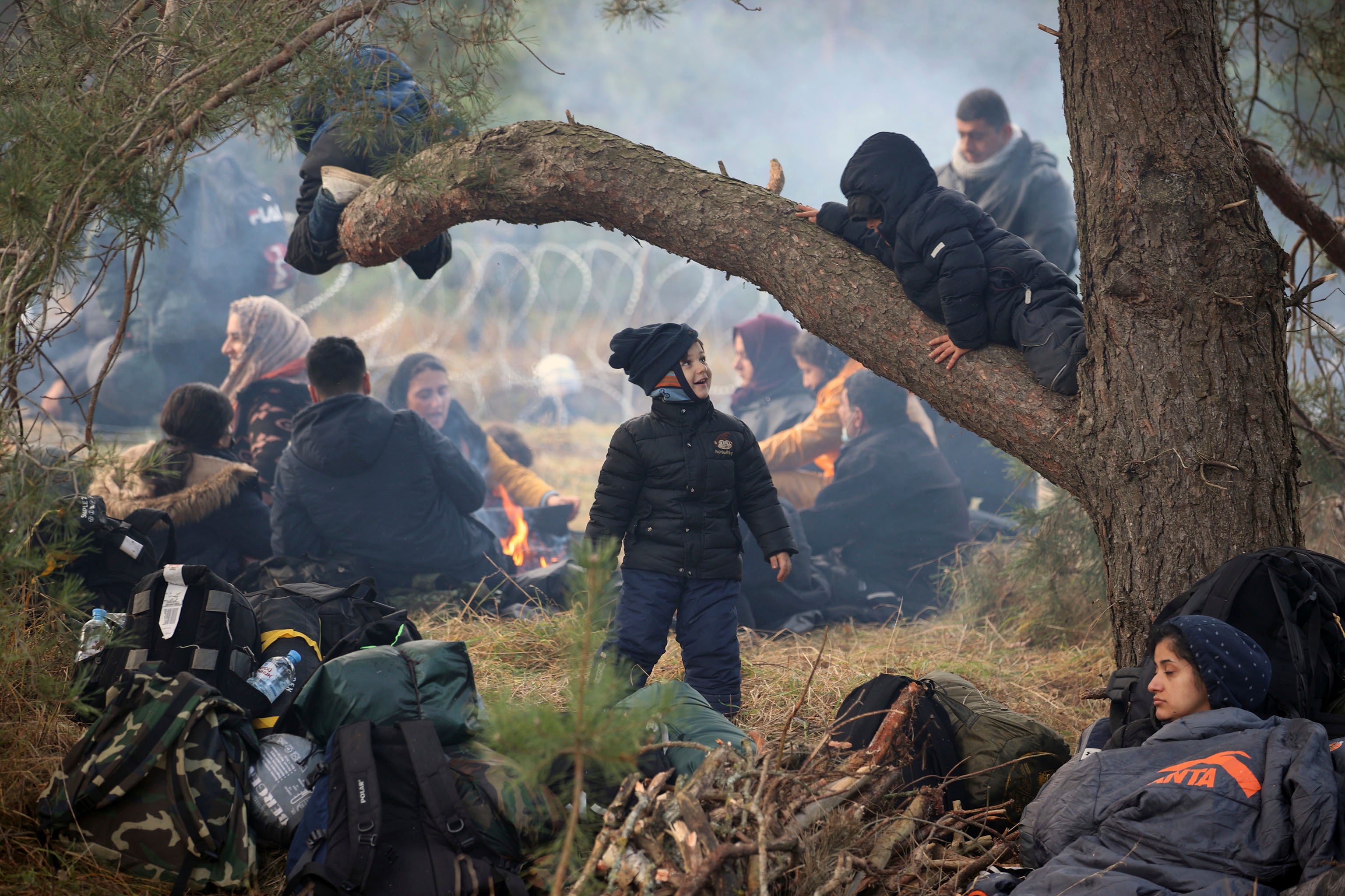 Migrants from the Middle East and elsewhere rest on the ground as they gather at the Poland border near Grodno, Belarus